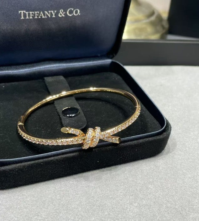 צמיד קשר עדין בגוון זהב ורוד משובץ זירקונים נוצצים למראה יוקרתי