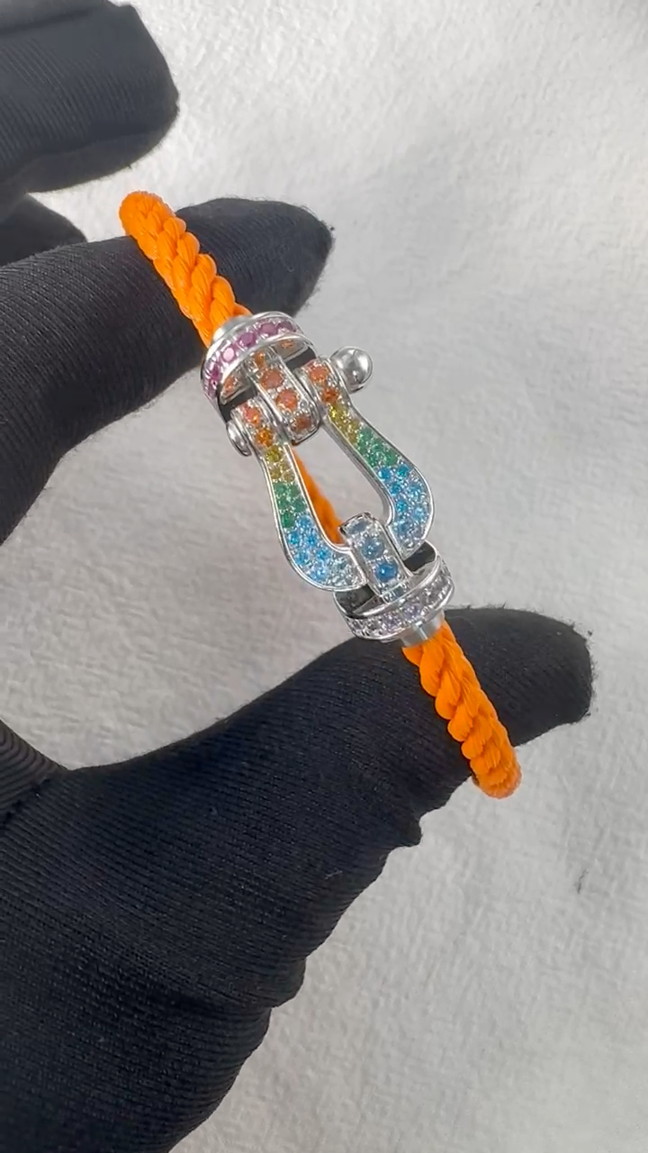 צמיד יוקרתי עם רצועת חבל כתומה ואבזם בגוון כסף משובץ בזירקונים צבעוניים