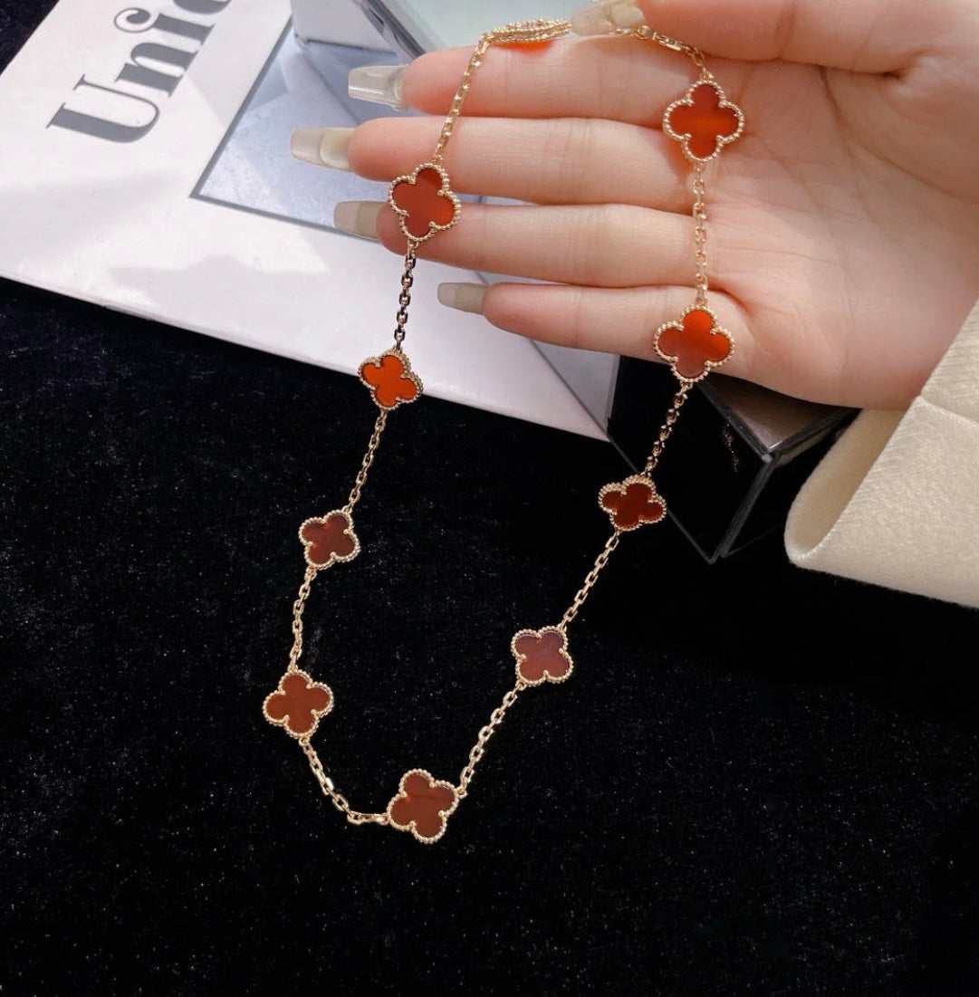 Halskette mit 10 goldfarbenen Kleeblättern und rotem Kleeblatt-Anhänger