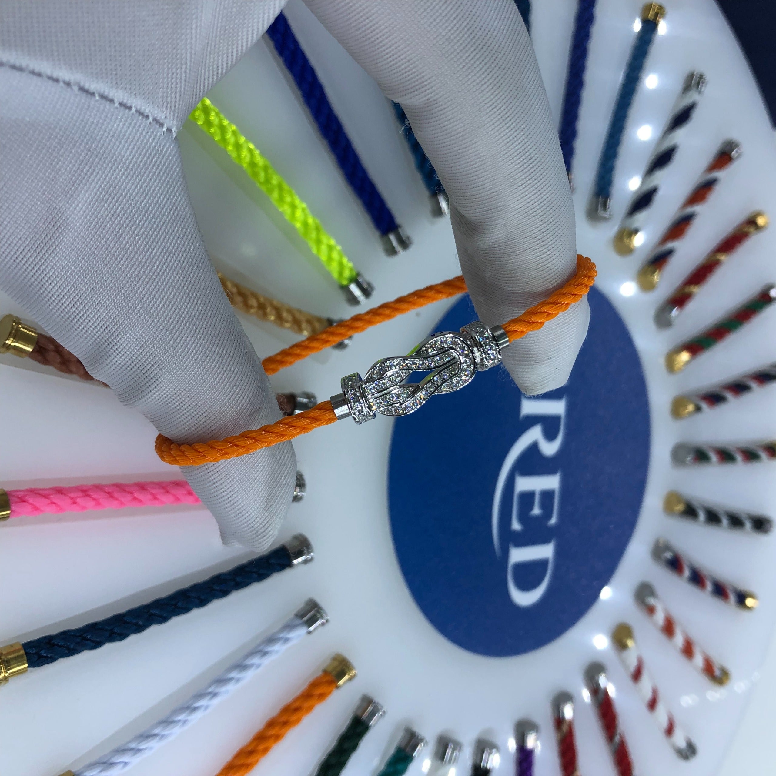 צמיד יוקרתי עם רצועת חבל כתומה ואבזם אינסוף בגוון כסף משובץ זירקונים נוצצים