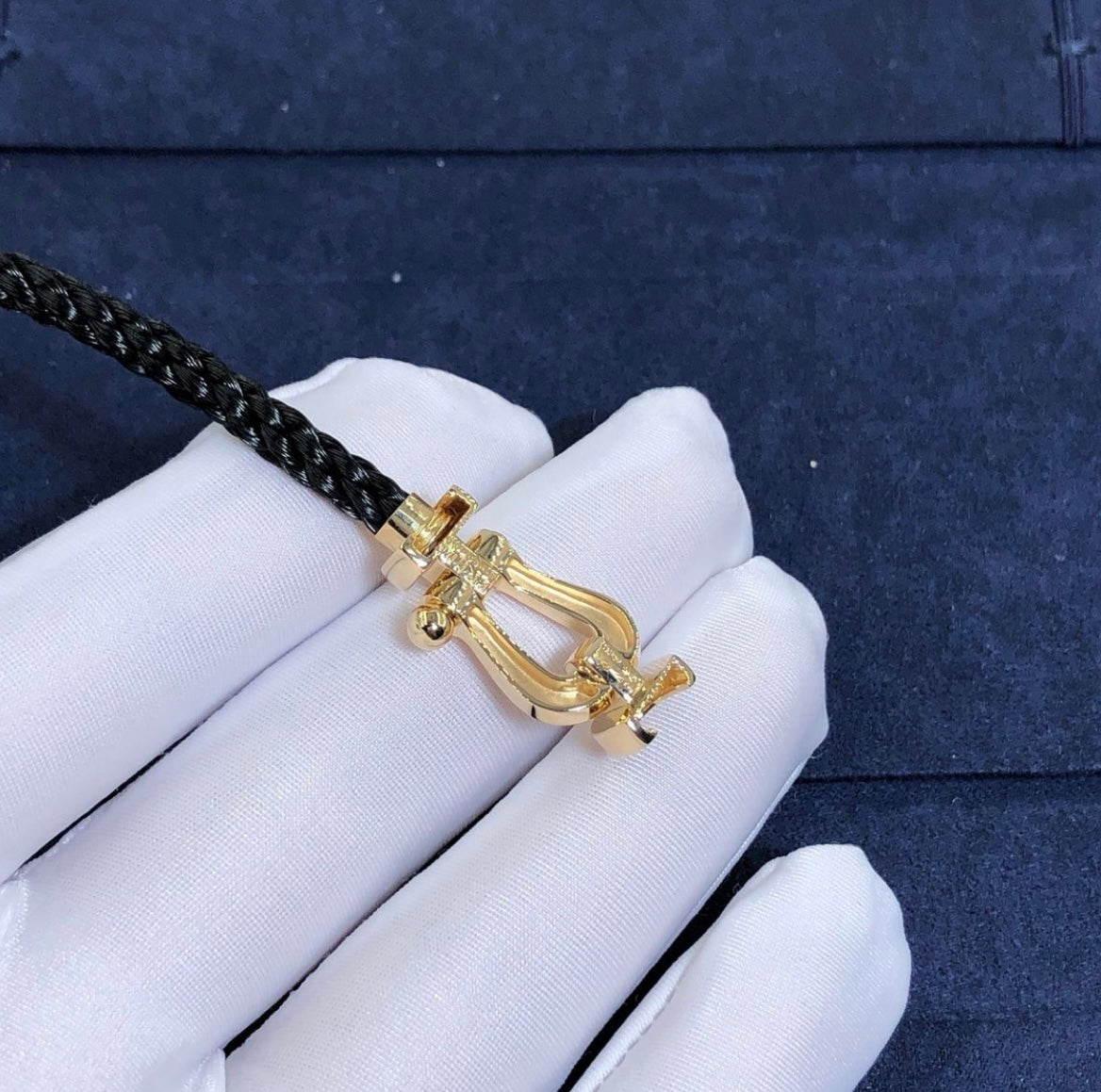 צמיד יוקרתי עם רצועות חבל שחורה ואבזם בגוון זהב מבריק