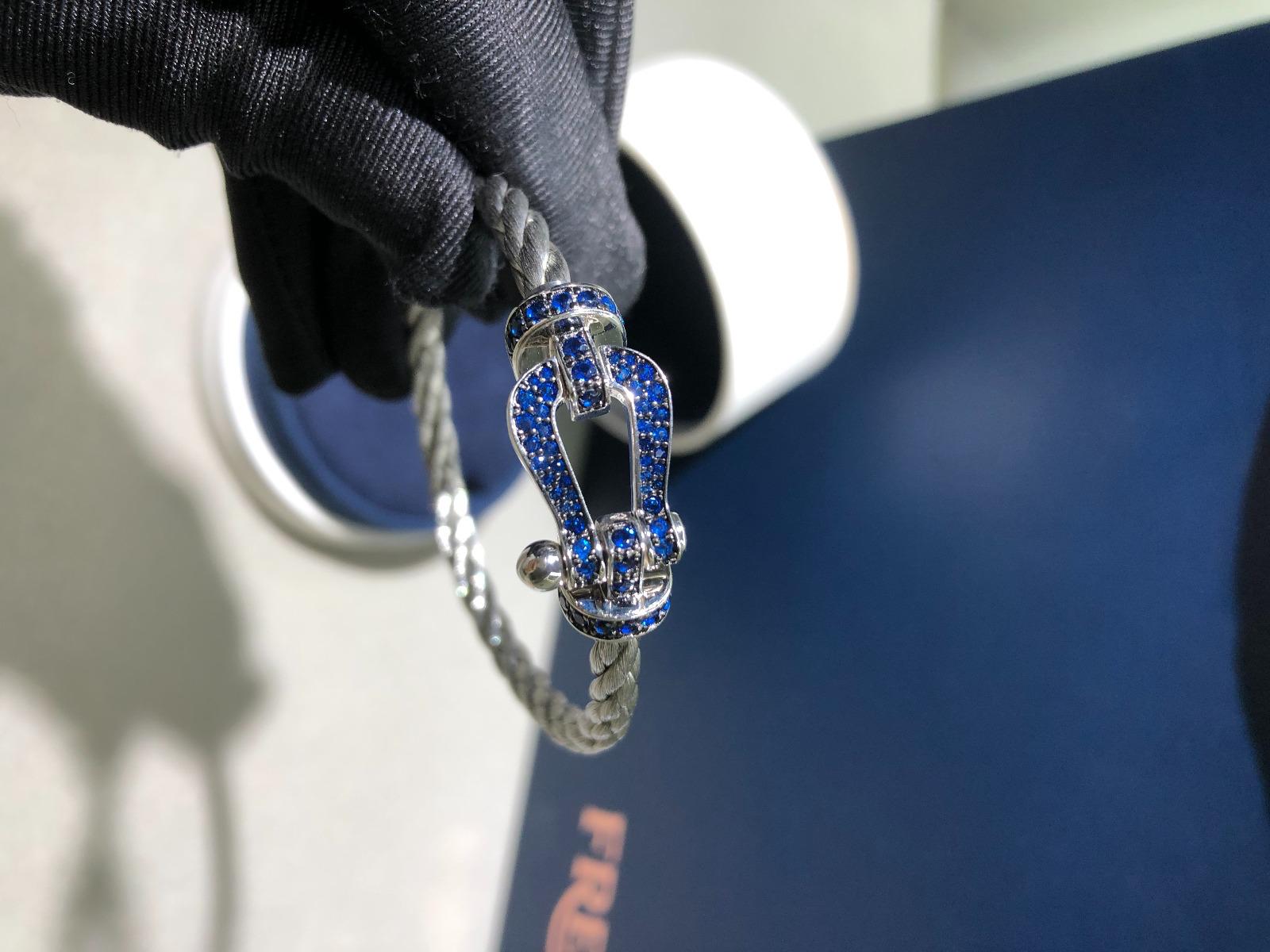 צמיד יוקרתי עם חוט (עבה) צבע אפור ואבזם כסוף משובץ זירקונים כחולים - Jewelluxe