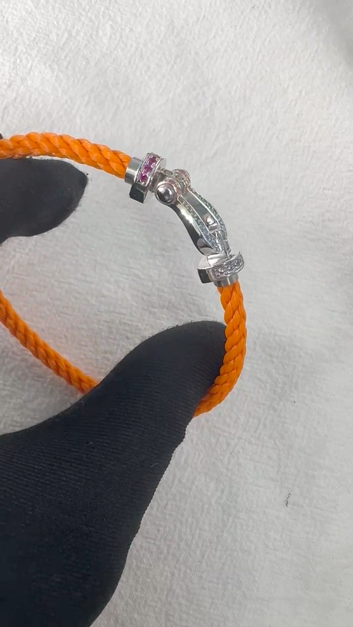 צמיד יוקרתי עם רצועת חבל כתומה ואבזם בגוון כסף משובץ בזירקונים צבעוניים