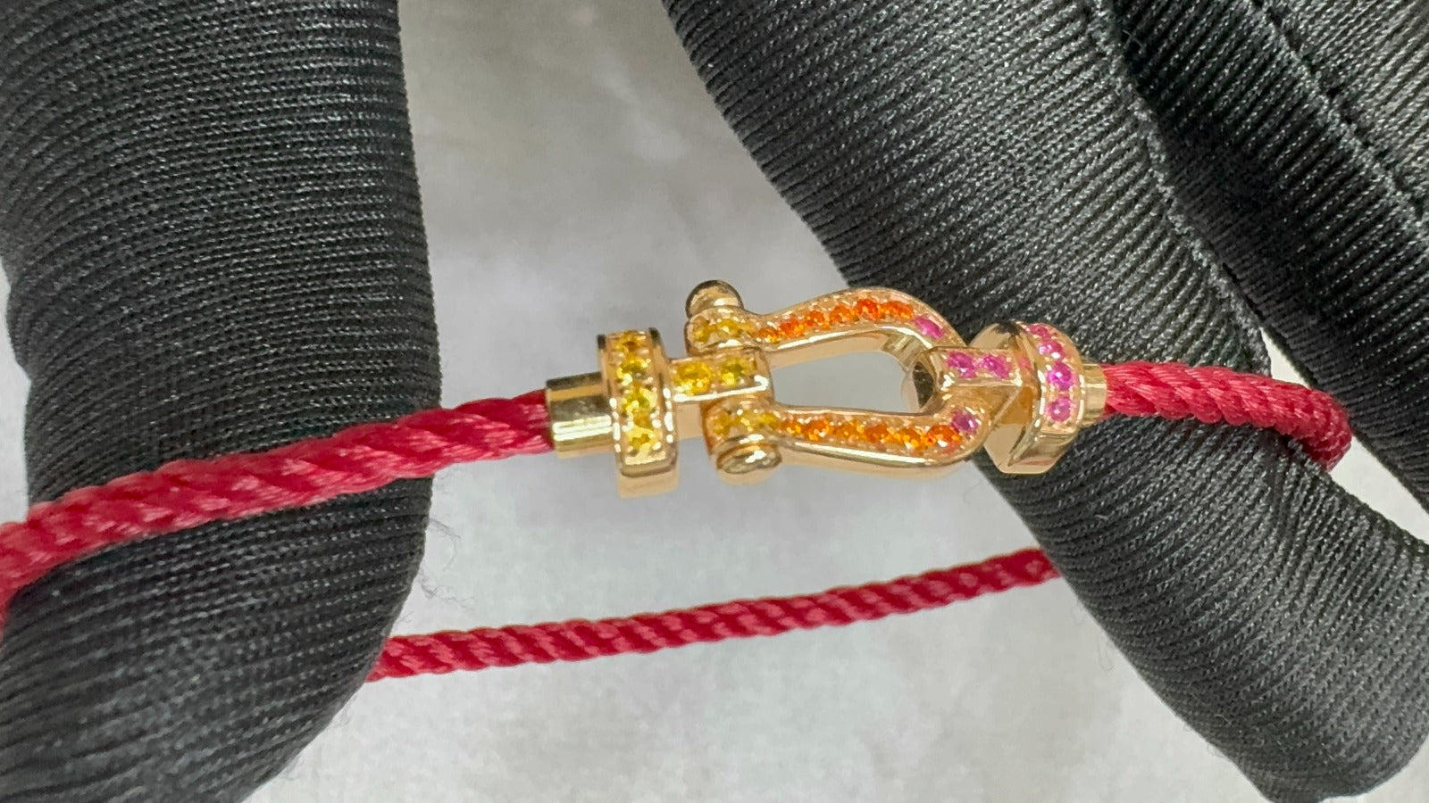 צמיד יוקרתי עם רצועת חבל ורודה דקה ואבזם בגוון זהב ורוד משובץ זירקונים צבעוניים