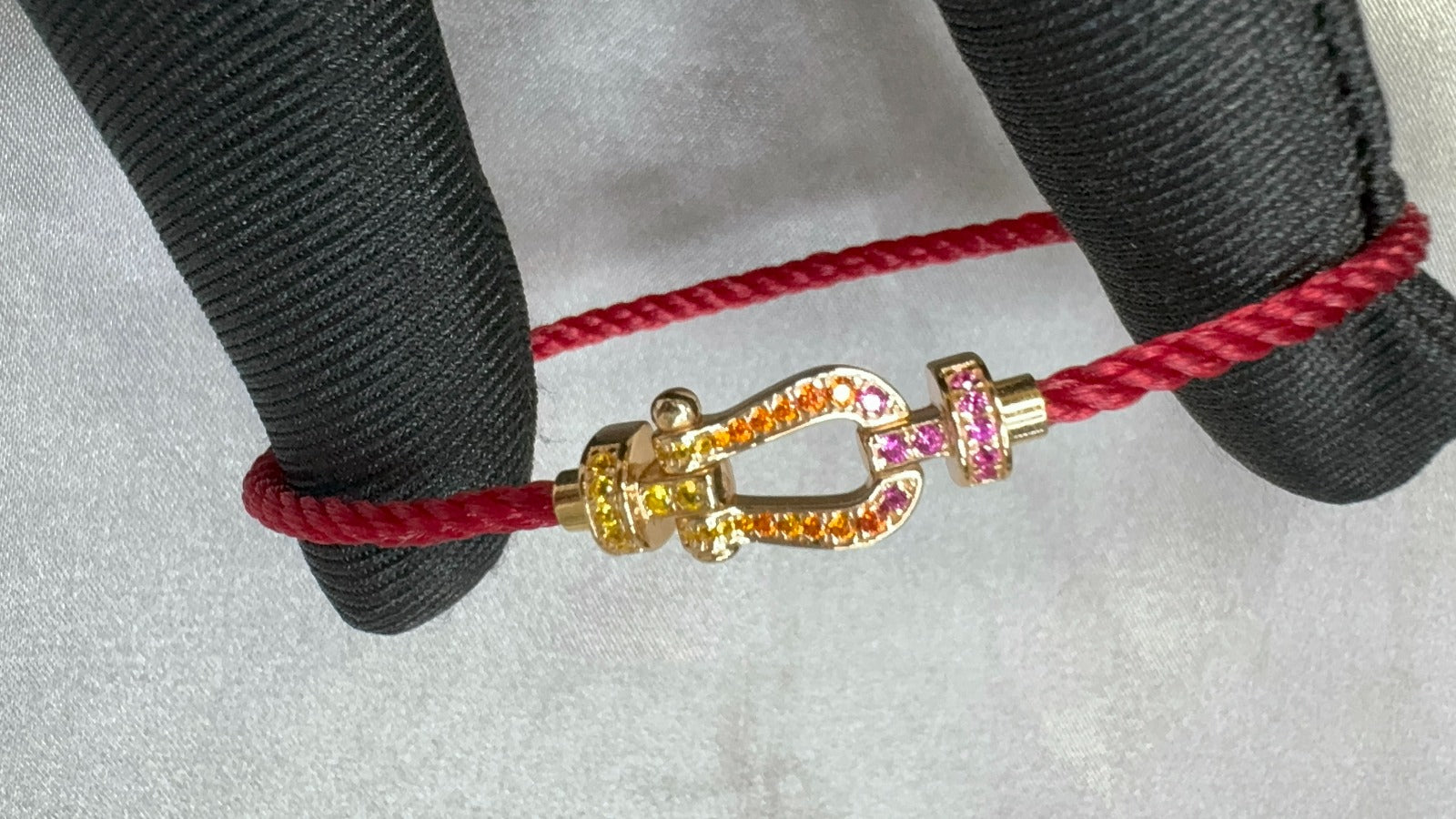צמיד יוקרתי עם רצועת חבל ורודה דקה ואבזם בגוון זהב ורוד משובץ זירקונים צבעוניים