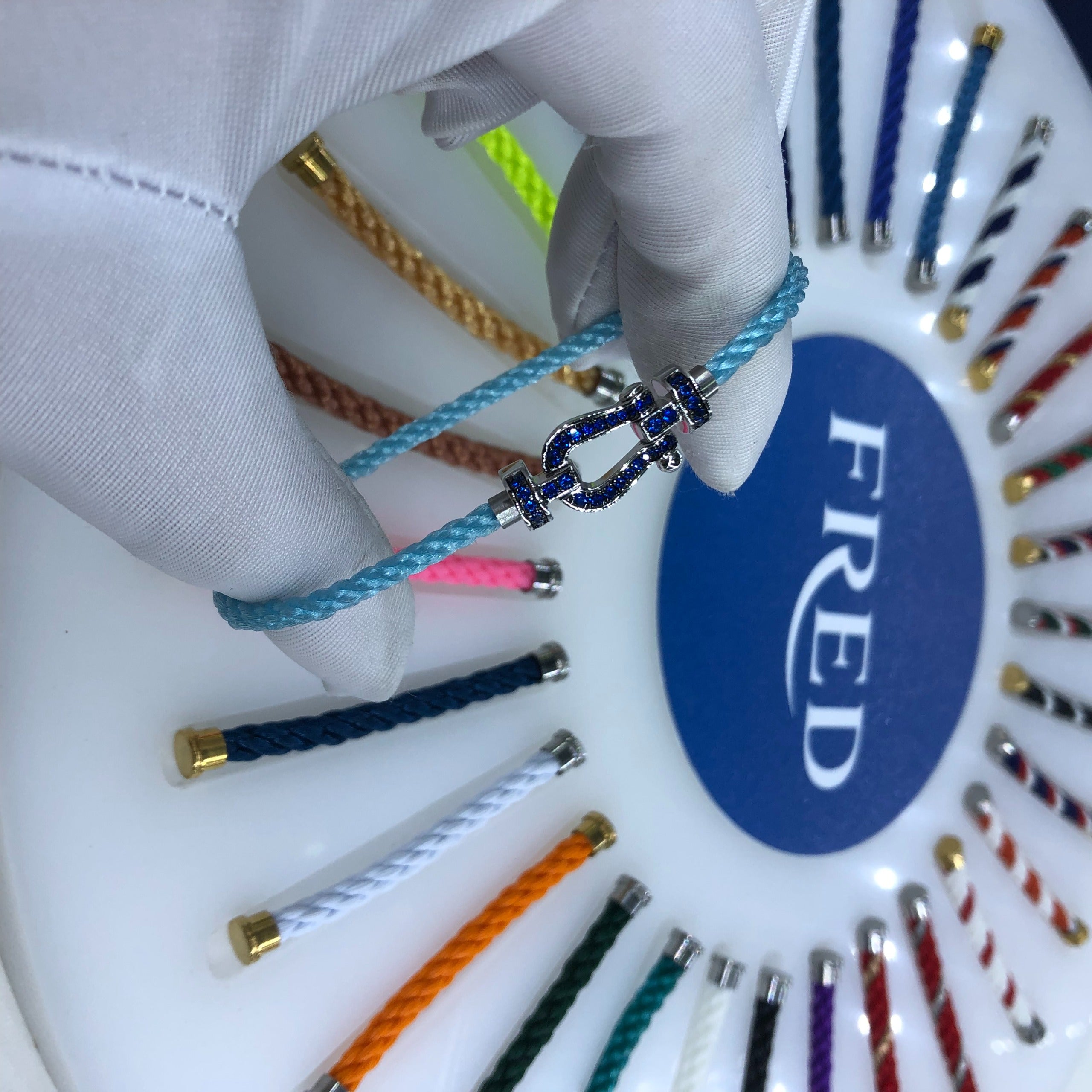 צמיד יוקרתי עם רצועת חבל (דק) בצבע תכלת ואבזם כסוף משובץ זירקונים כחולים נוצצים