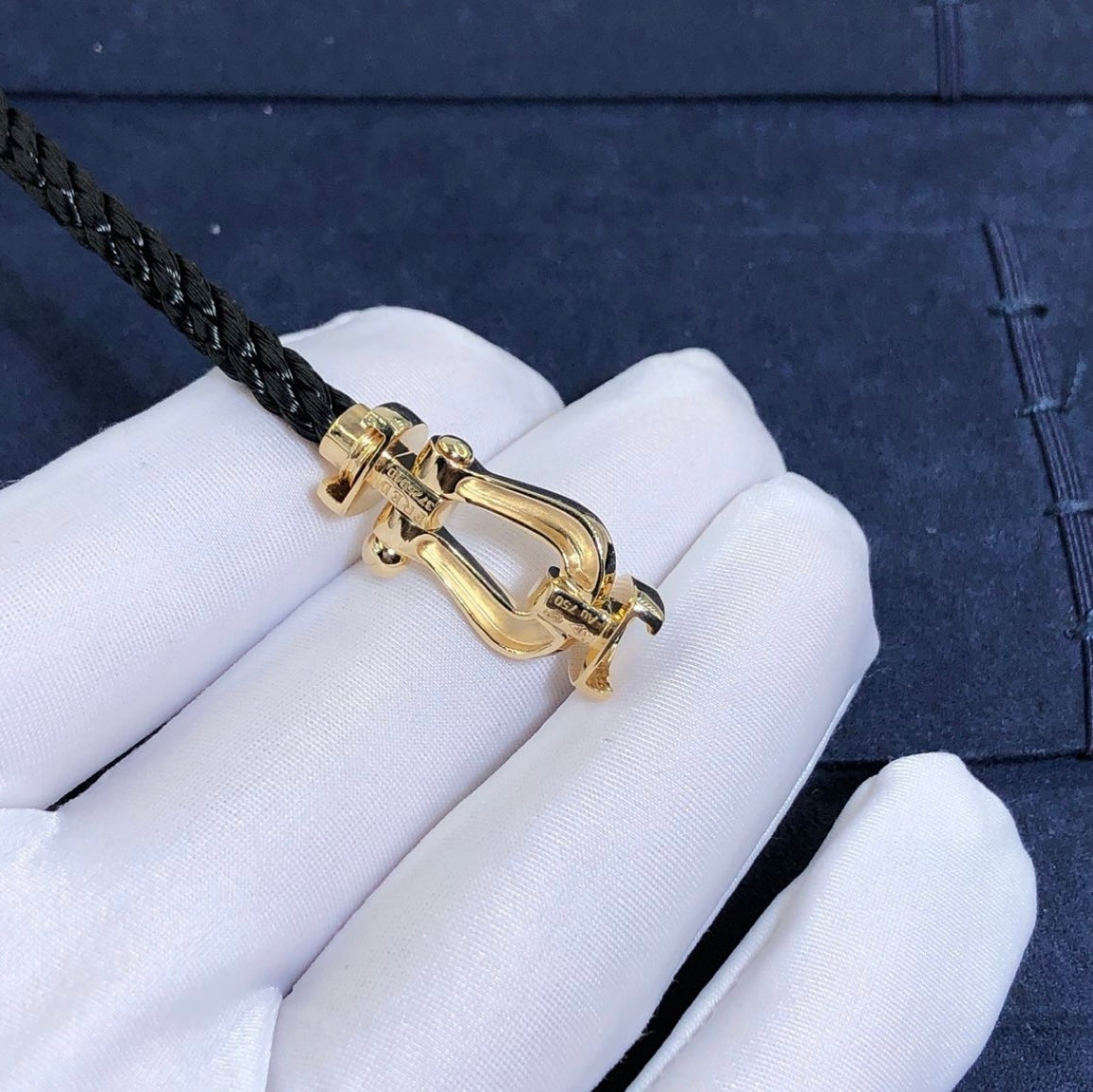 צמיד יוקרתי עם רצועות חבל שחורה ואבזם בגוון זהב מבריק