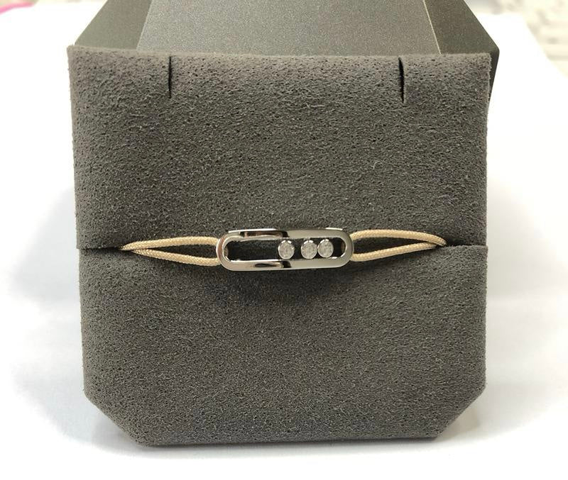 צמיד אהבה – חוט בגוון קרם עם אבזם בגוון כסף, 3 זירקונים נעים