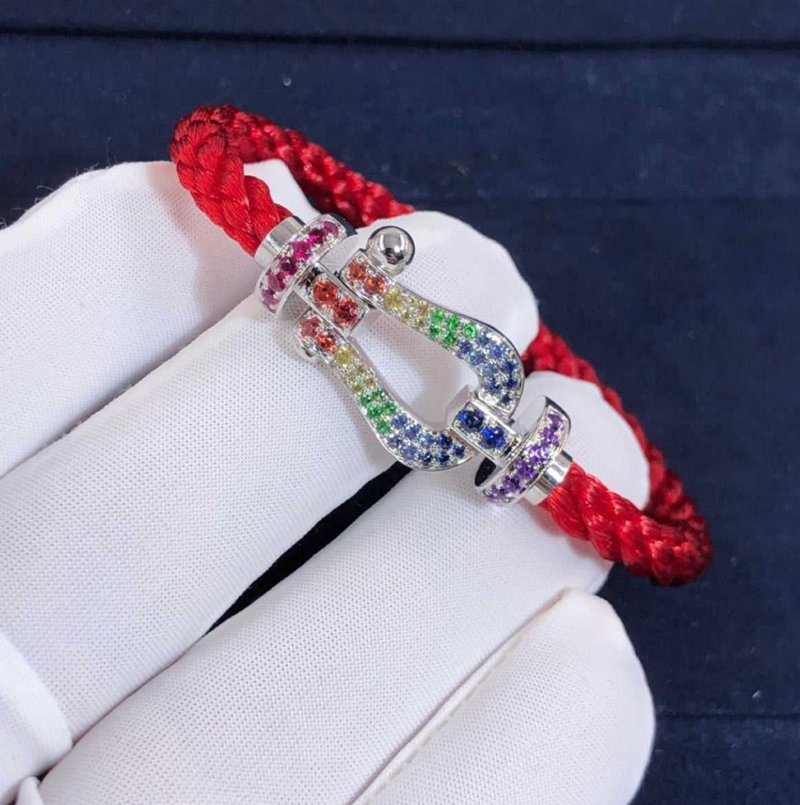 צמיד יוקרתי עם רצועת חבל אדומה ואבזם בגוון כסף משובץ בזירקונים בצבעי הקשת