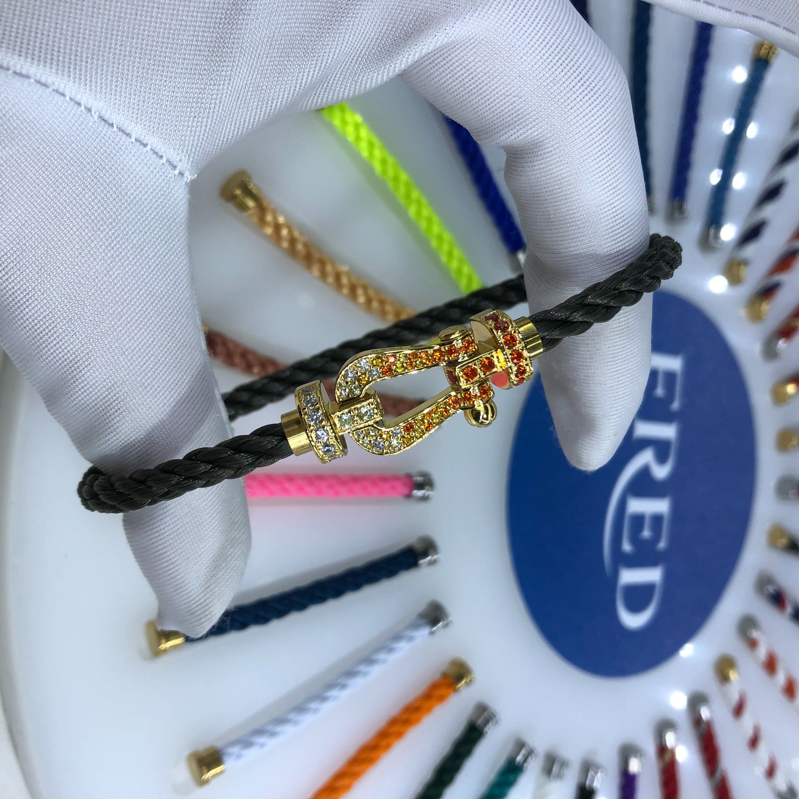 צמיד יוקרתי עם רצועת חבל בגוון שחור ואבזם בגוון זהב ועיצוב רולאן גארוס RG משובץ זירקונים