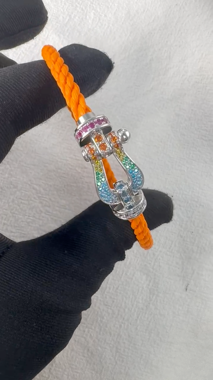 צמיד יוקרתי עם רצועת חבל כתומה ואבזם בגוון כסף משובץ בזירקונים צבעוניים