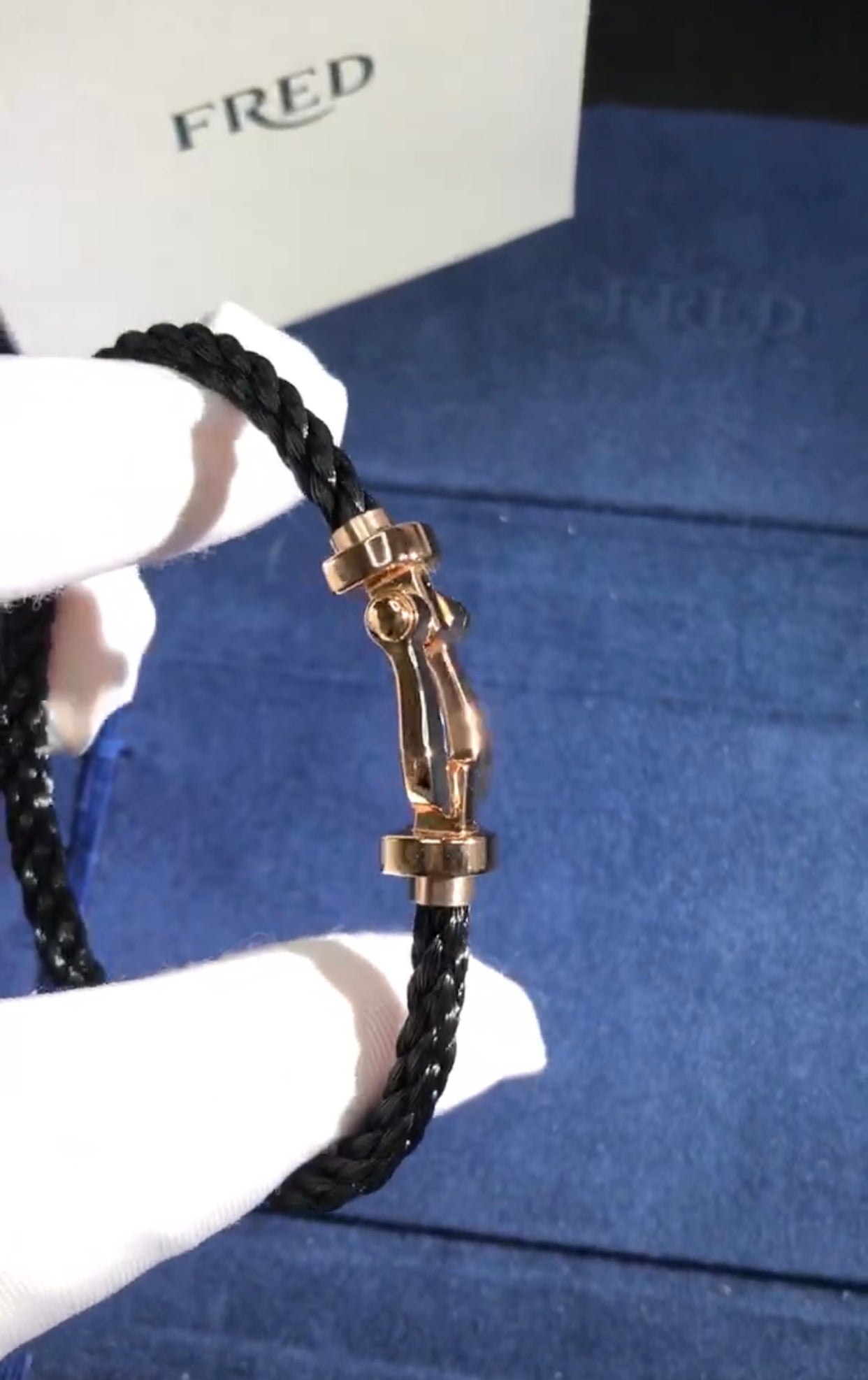 צמיד יוקרתי עם רצועת חבל שחורה ואבזם בגוון רוז־גולד מבריק