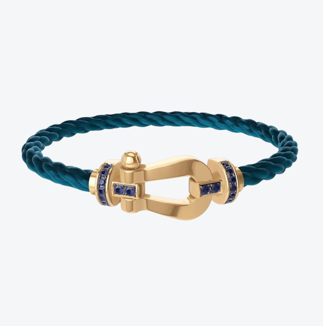 צמיד יוקרתי עם רצועת חבל בגוון ריביירה ואבזם בגוון זהב משובץ זירקונים עיצוב RG רולאן גארוס