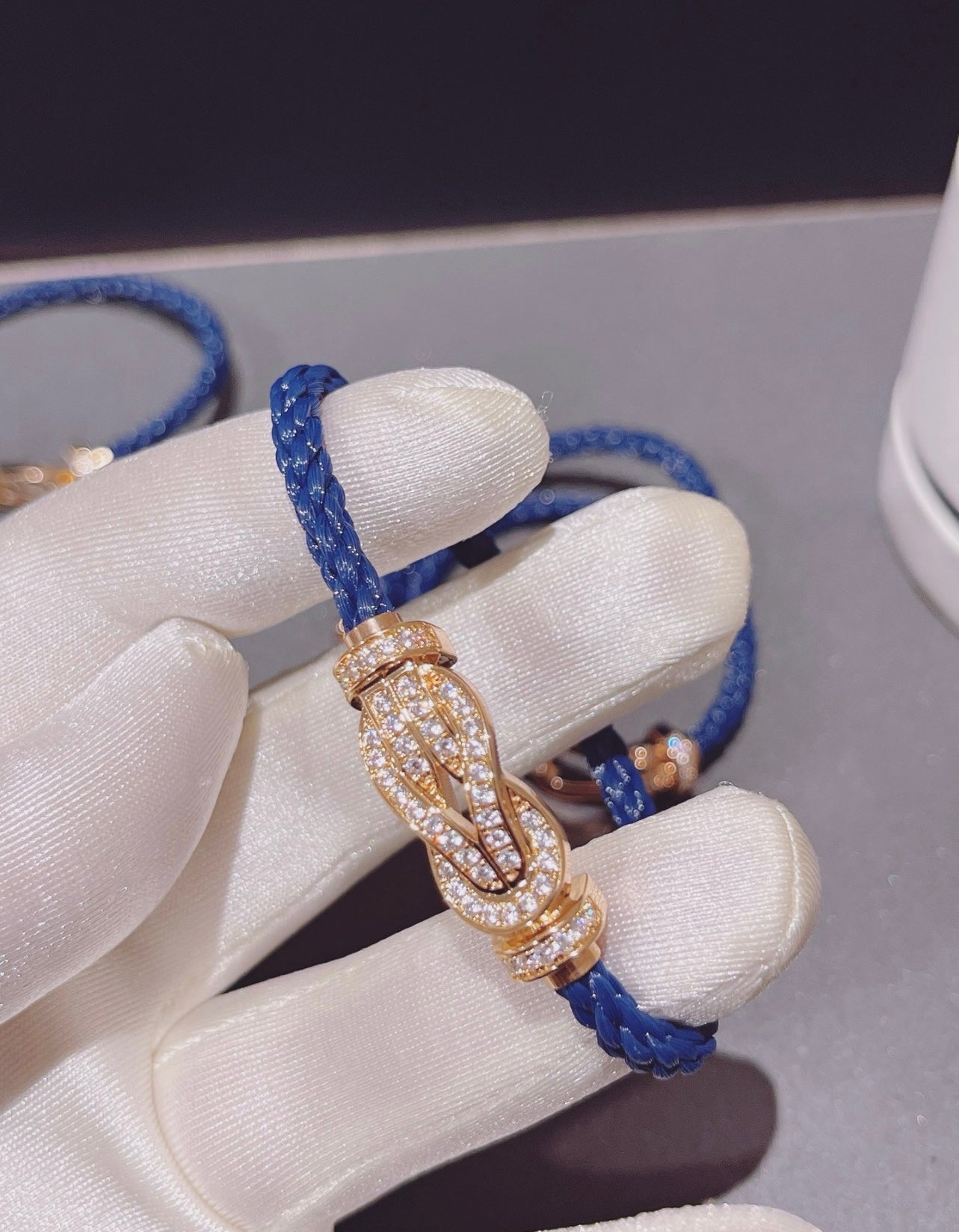 צמיד יוקרתי עם רצועת חבל כחולה עם אבזם אינסוף בגוון זהב ורוד משובץ זירקונים