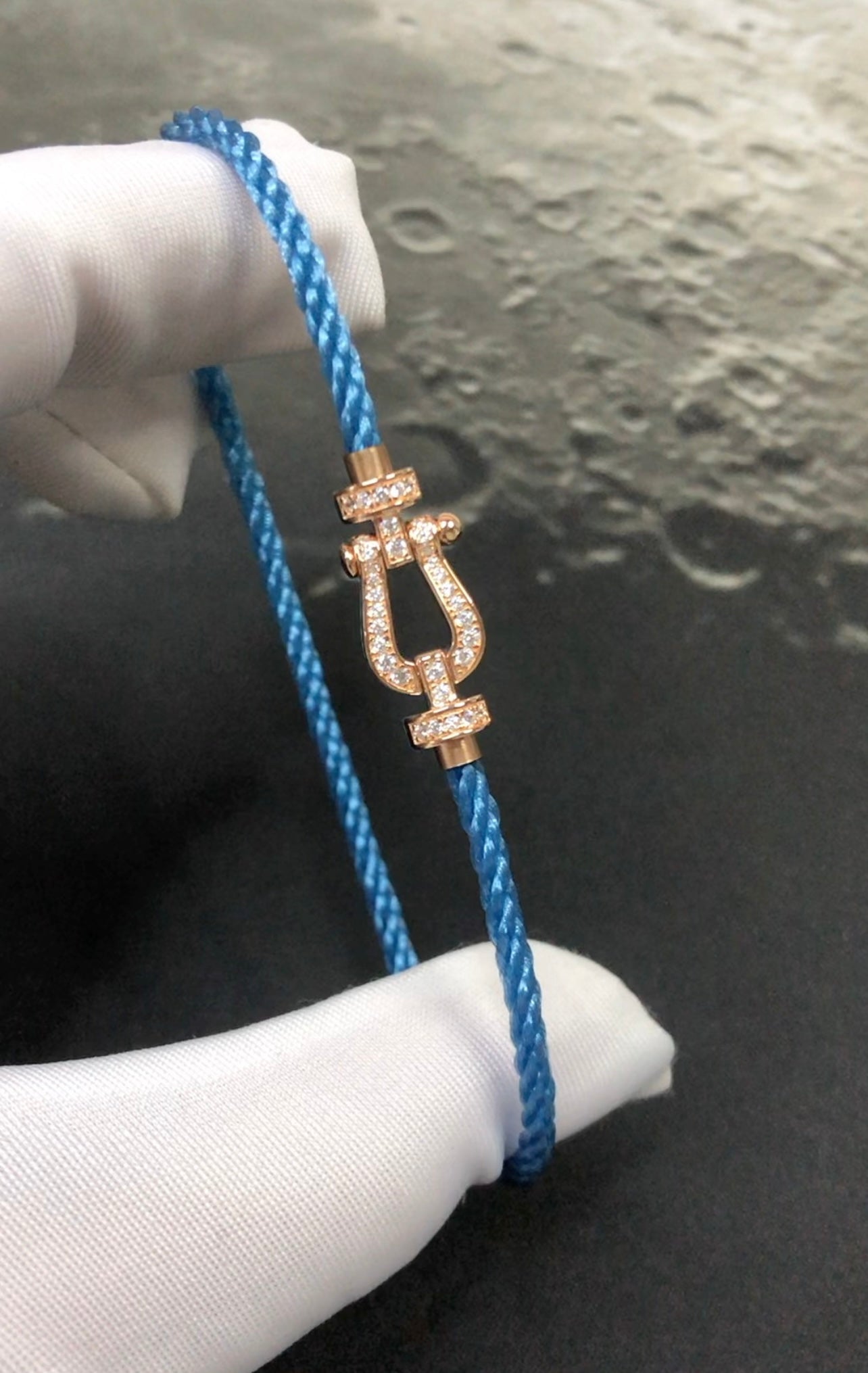 צמיד יוקרתי עם רצועת חבל בגוון כחול ג’ינס אבזם בגוון זהב ורוד משובץ זירקונים