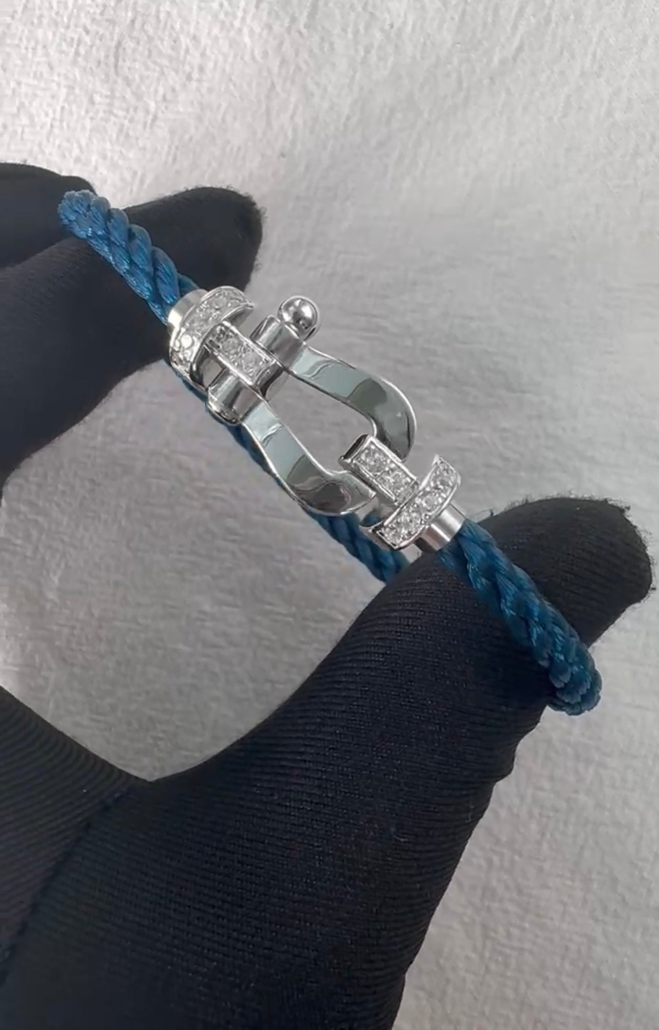 צמיד יוקרתי עם רצועת חבל בגוון ריביירה ואבזם בגוון כסף משובץ בחצי זירקונים