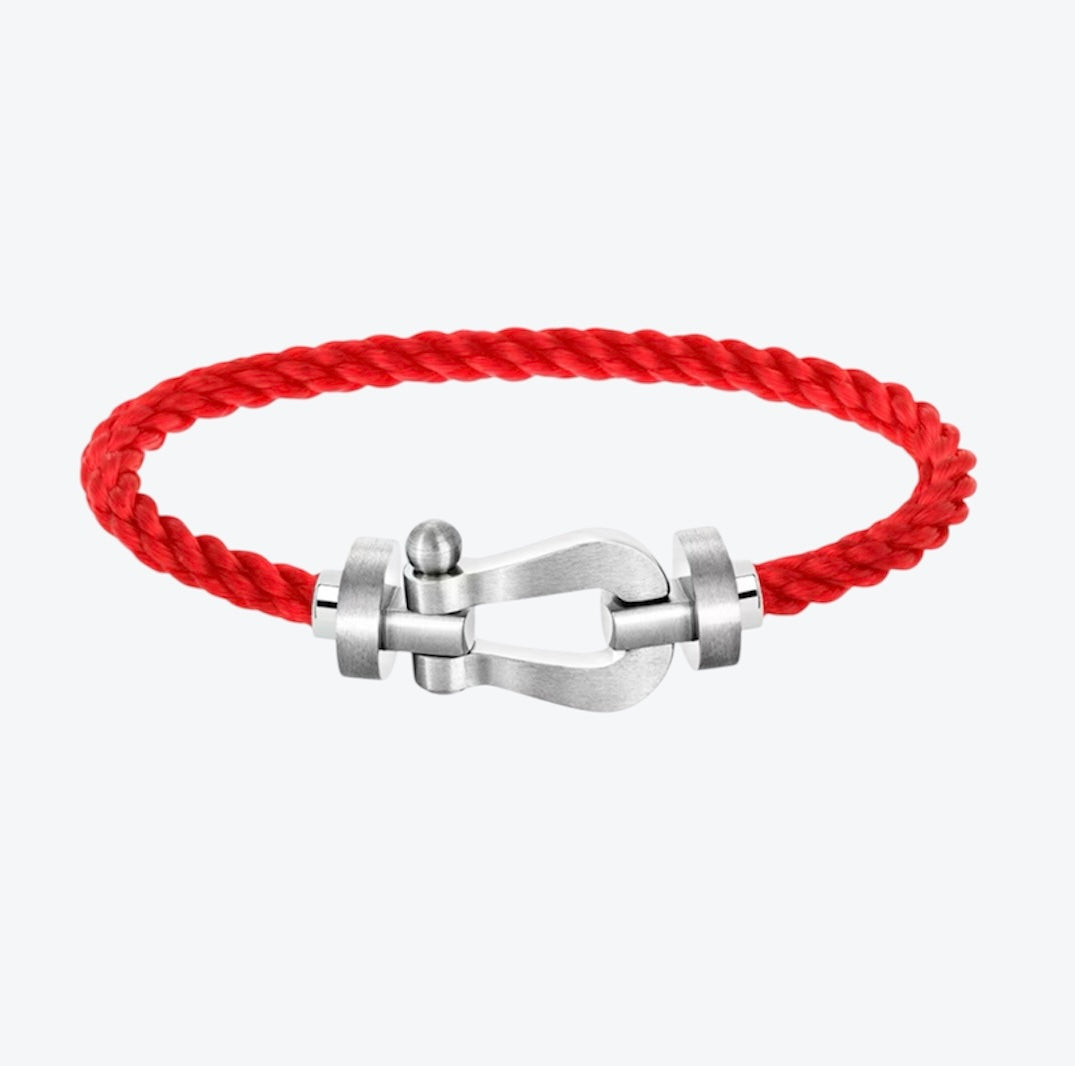 Bracelet luxueux avec un cordon rouge et une boucle argentée brossée