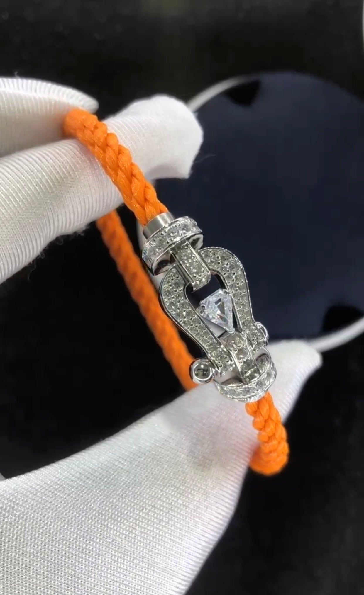 Bracelet luxueux avec une sangle en corde noire et une boucle couleur or rose sertie de zircons, avec une pierre centrale de 0,5 carat