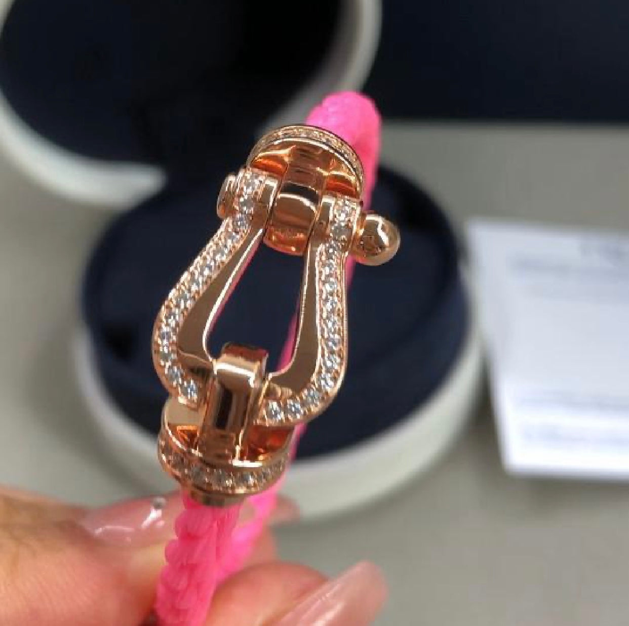 צמיד יוקרתי עם רצועת חבל ורודה ואבזם בגוון זהב ורוד משובץ בשורת זירקונים