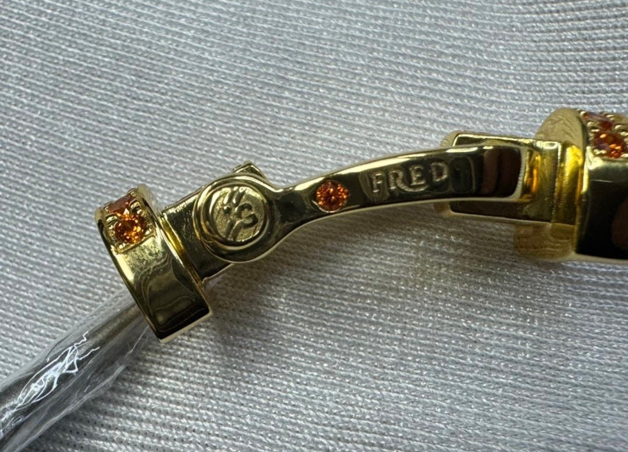 צמיד יוקרתי עם רצועת חבל בגווני כתום, לבן וצהוב ואבזם בגוון זהב משובץ בזירקונים כתומים