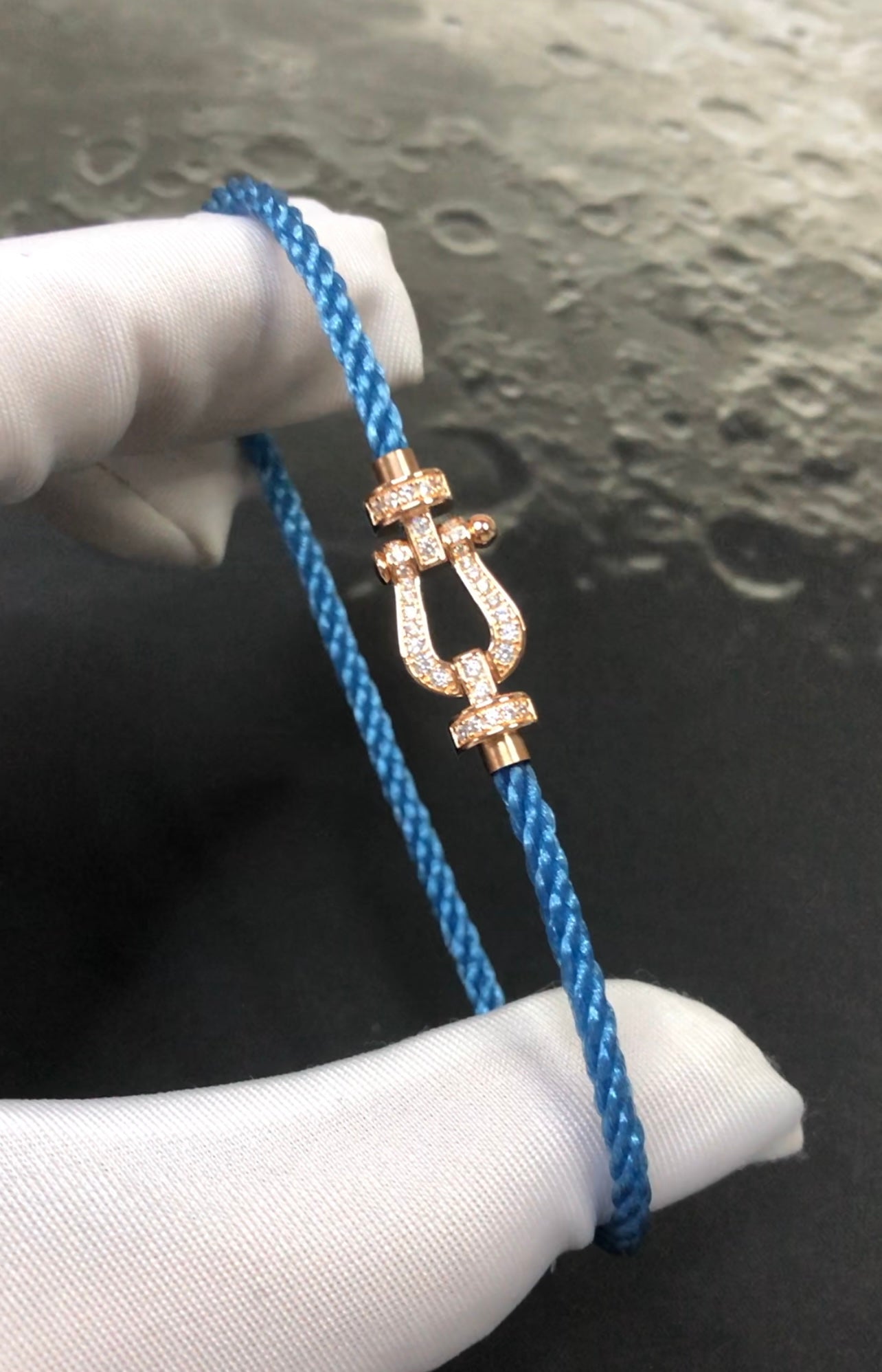 צמיד יוקרתי עם רצועת חבל בגוון כחול ג’ינס אבזם בגוון זהב ורוד משובץ זירקונים