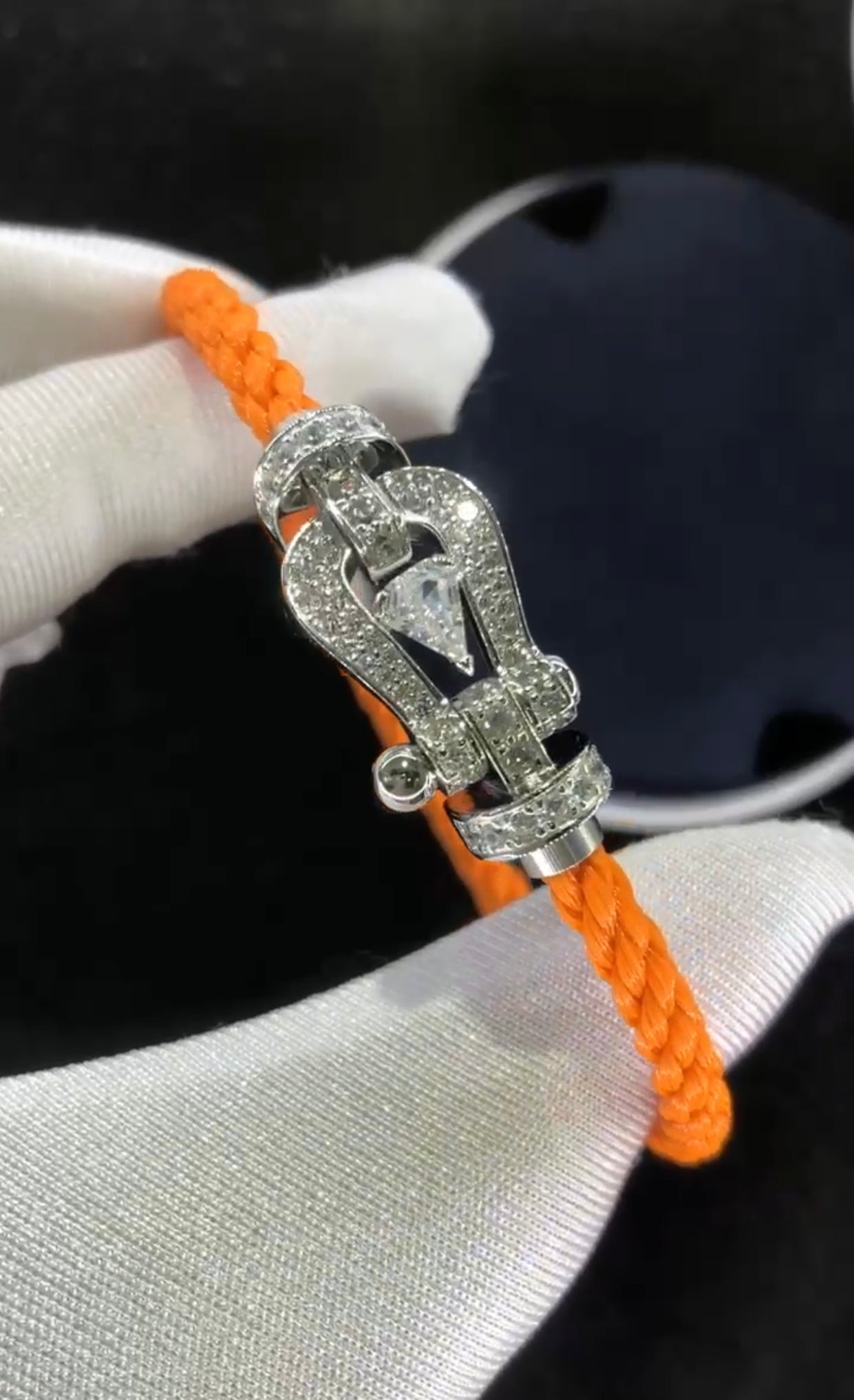 Bracelet luxueux avec une sangle en corde noire et une boucle couleur or rose sertie de zircons, avec une pierre centrale de 0,5 carat