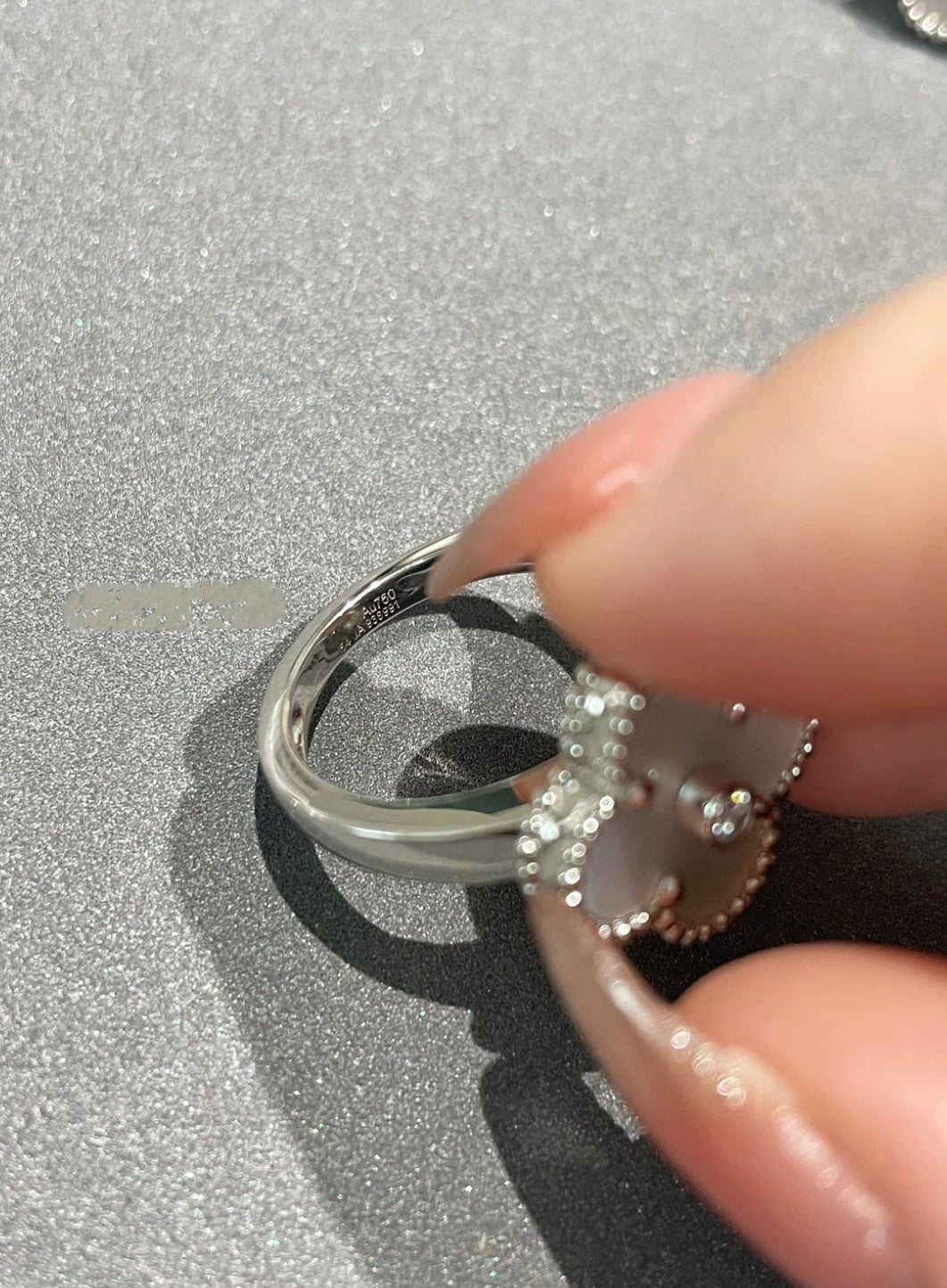 Weißer Kleeblatt-Ring, in der Mitte mit einem funkelnden Zirkon besetzt