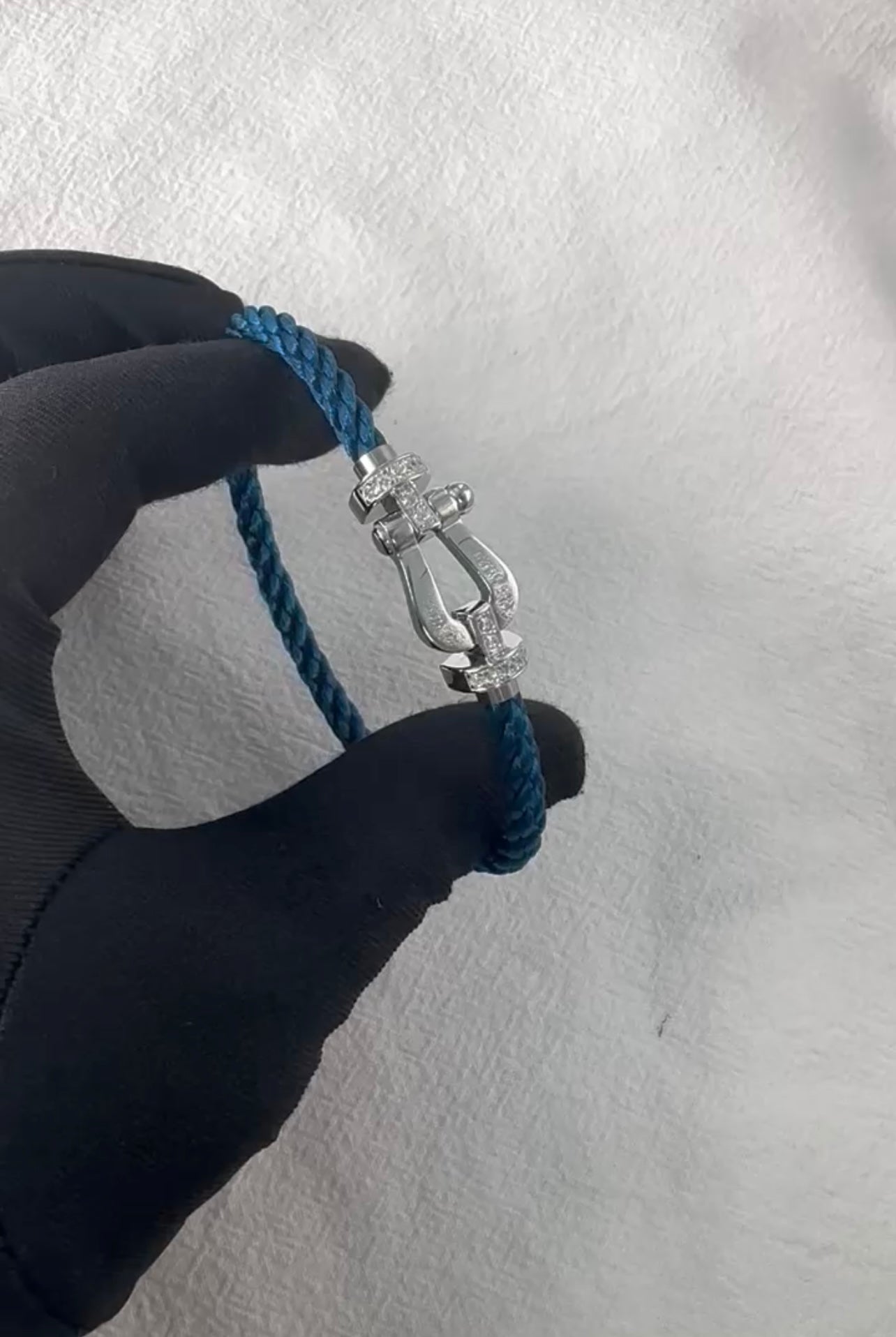 צמיד יוקרתי עם רצועת חבל בגוון ריביירה ואבזם בגוון כסף משובץ בחצי זירקונים