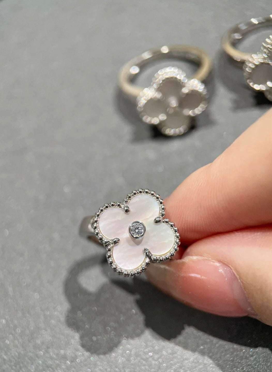 Weißer Kleeblatt-Ring, in der Mitte mit einem funkelnden Zirkon besetzt