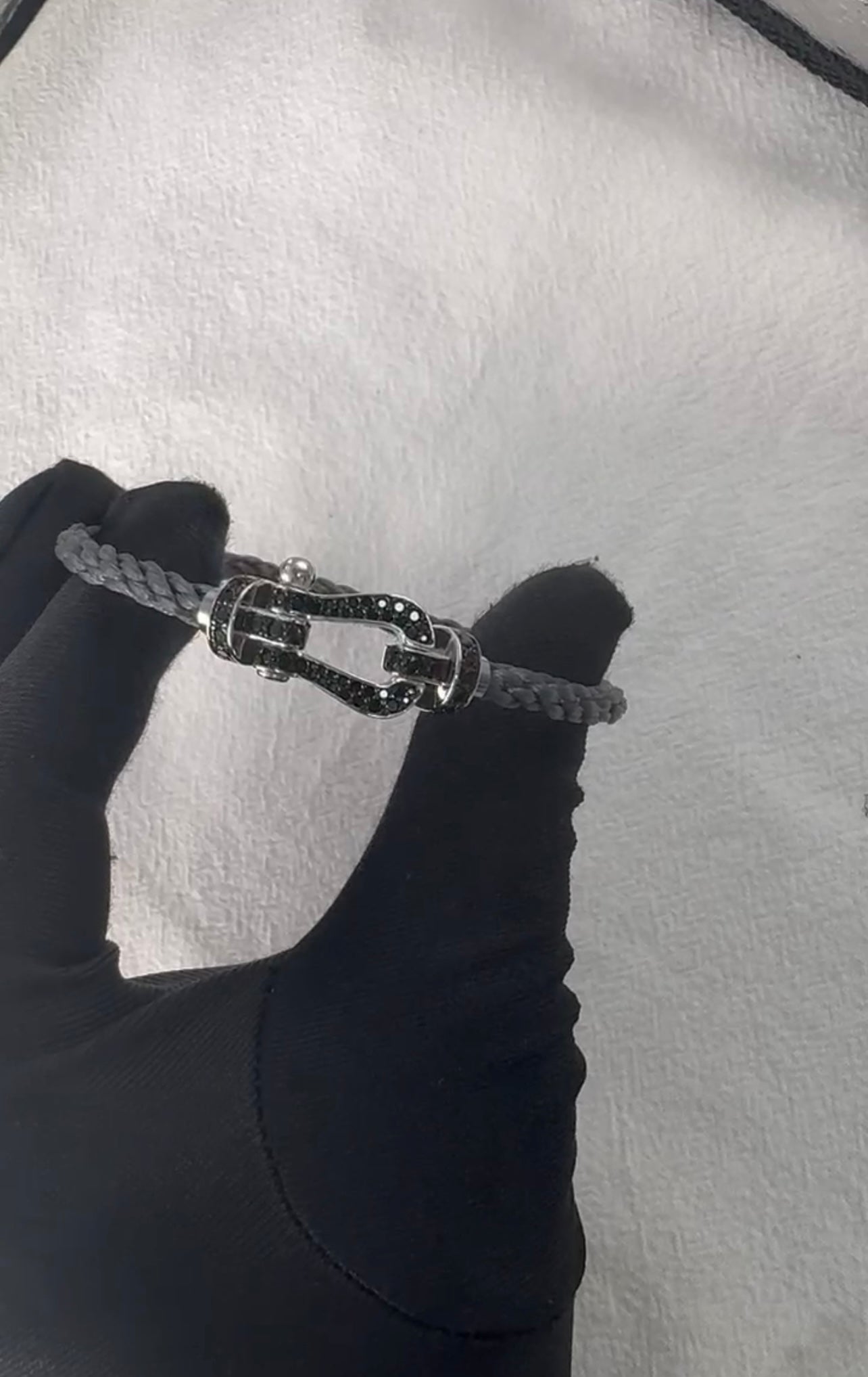 צמיד יוקרתי עם רצועת חבל אפורה ואבזם בגוון כסף משובץ בזירקונים שחורים