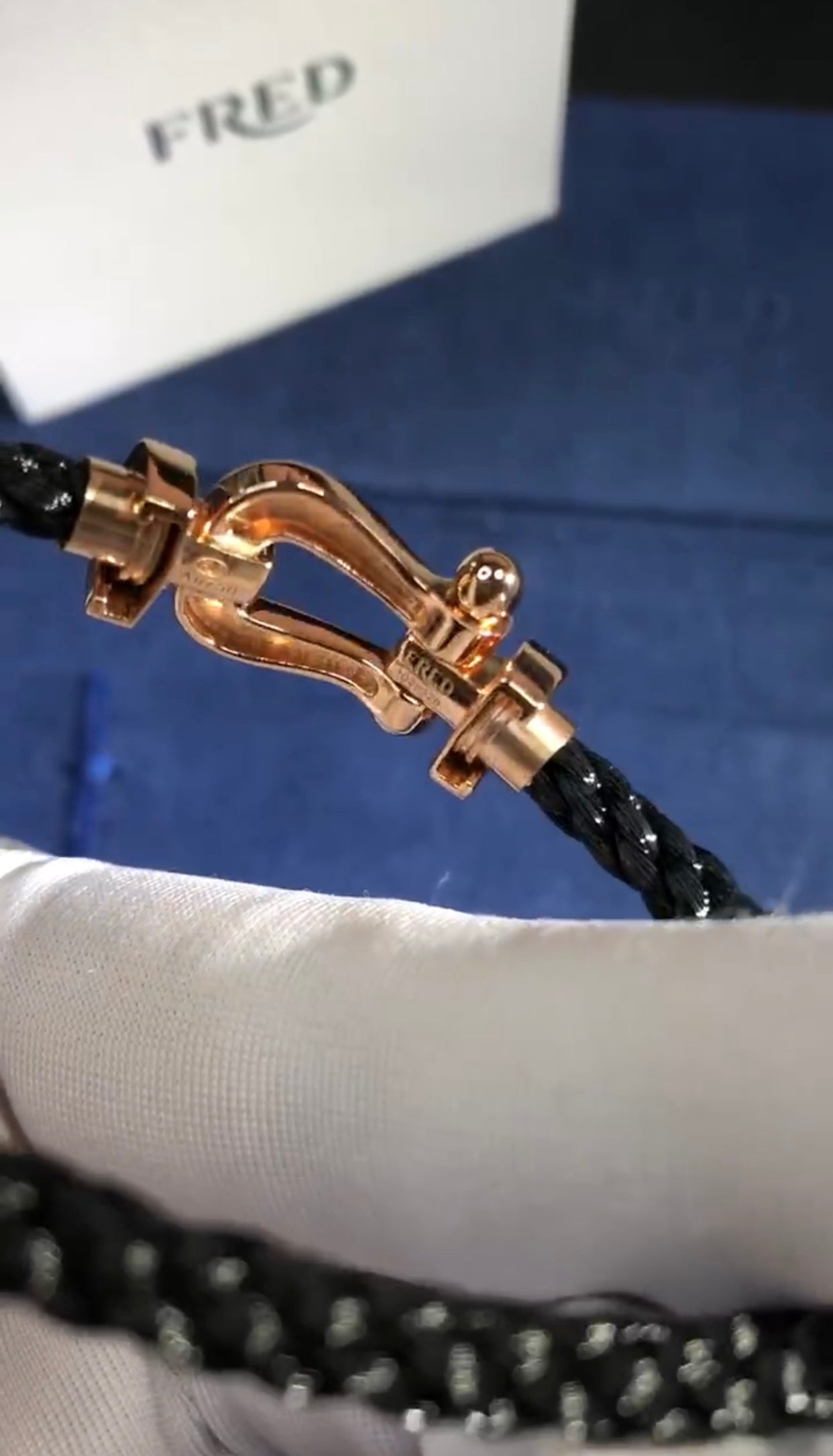 צמיד יוקרתי עם רצועת חבל שחורה ואבזם בגוון רוז־גולד מבריק