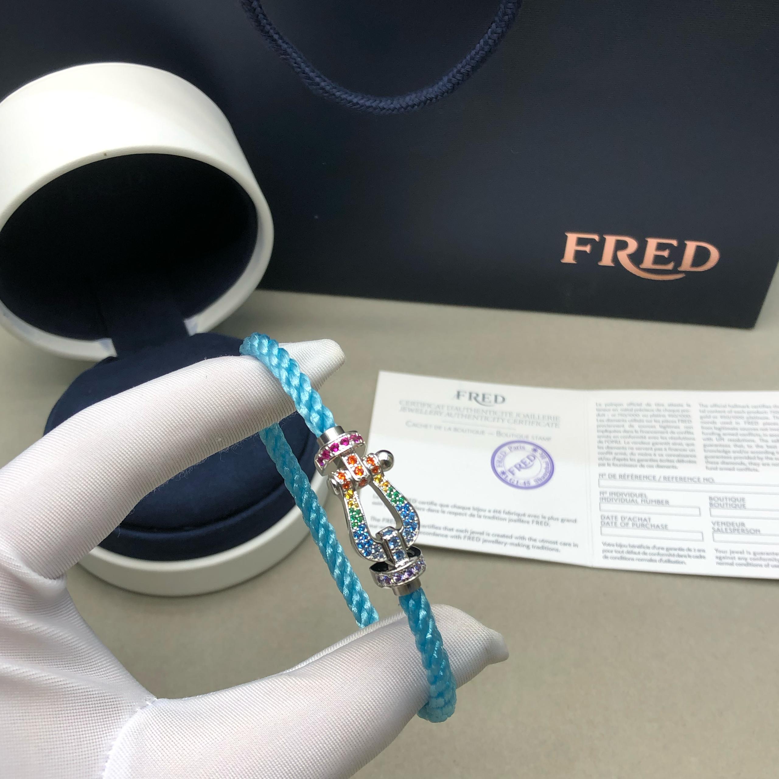 צמיד יוקרתי עם רצועת חבל בגוון תכלת ואבזם בגוון כסף משובץ זרקונים צבעוניים