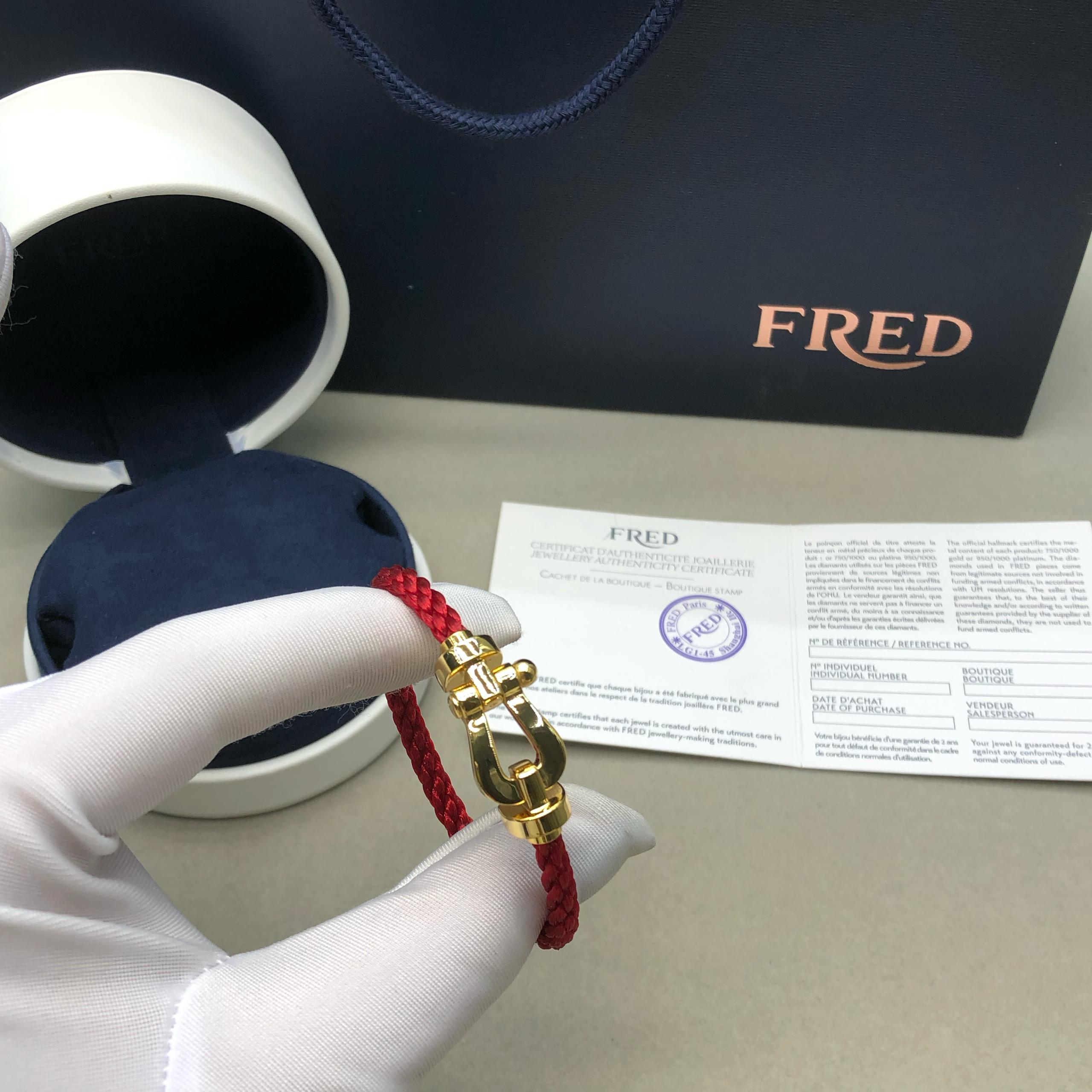 צמיד יוקרתי עם רצועת חבל אדומה ואבזם בגוון זהב מבריק בעיצוב עוצמתי