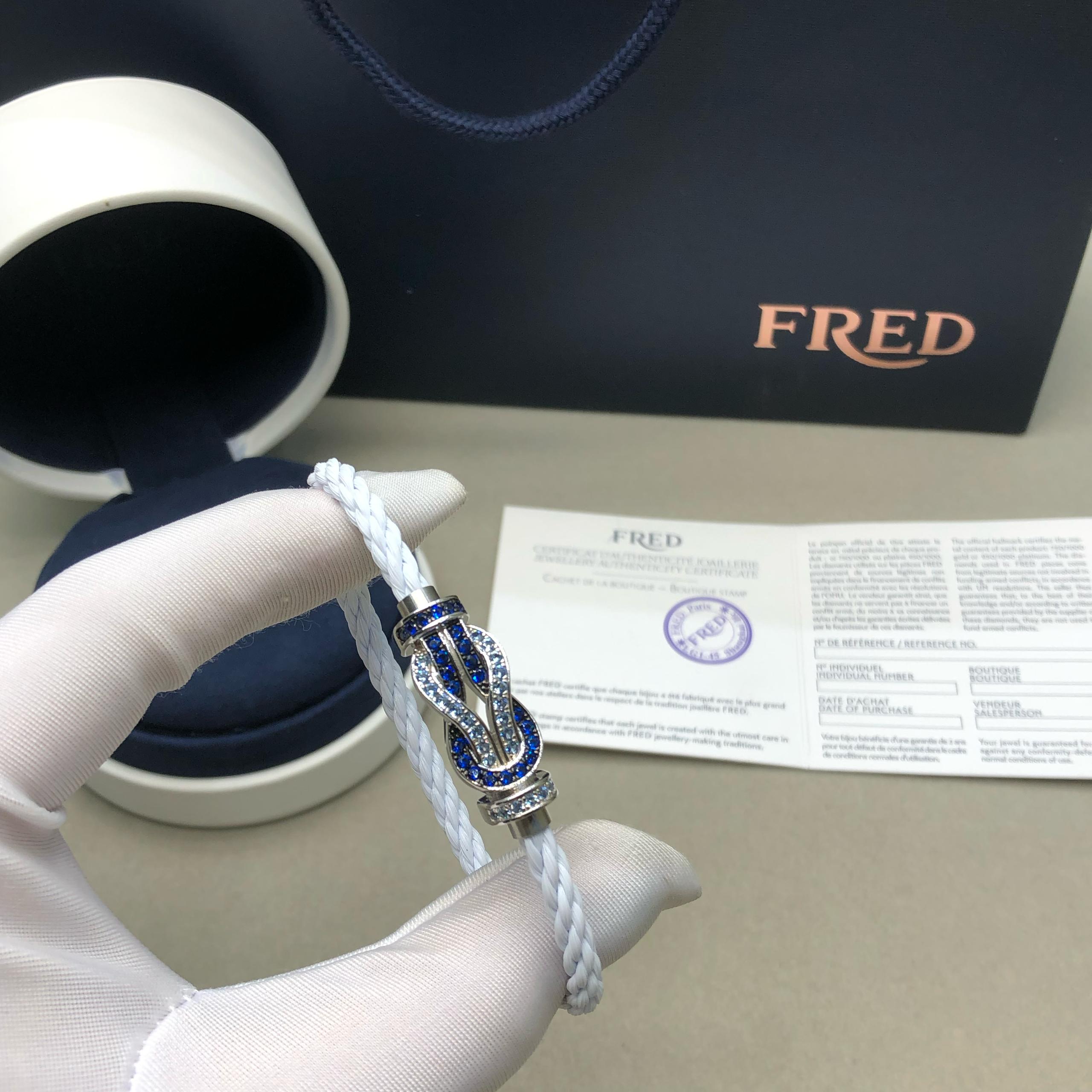 צמיד יוקרתי עם רצועת חבל לבנה ואבזם אינסוף בגוון כסף משובץ זירקונים כחולים