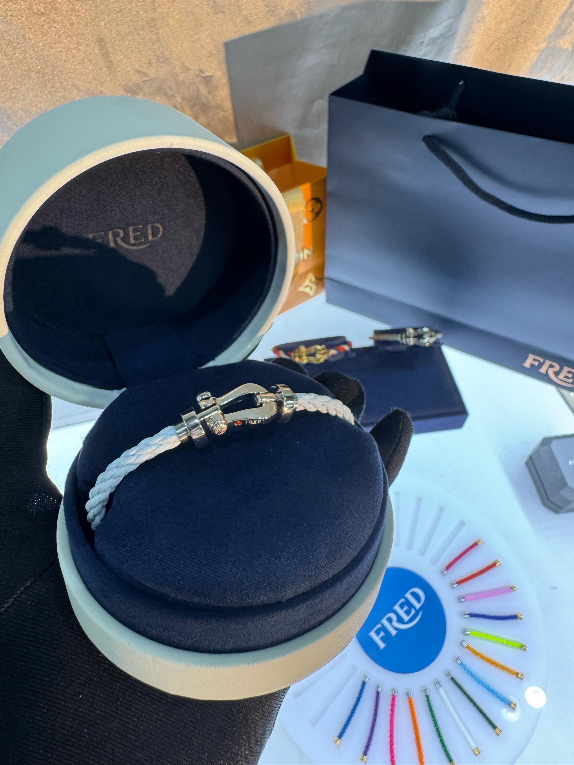 צמיד יוקרתי עם רצועת חבל בגוון לבן אבזם בגוון כסף ועיצוב רולאן גארוס RG