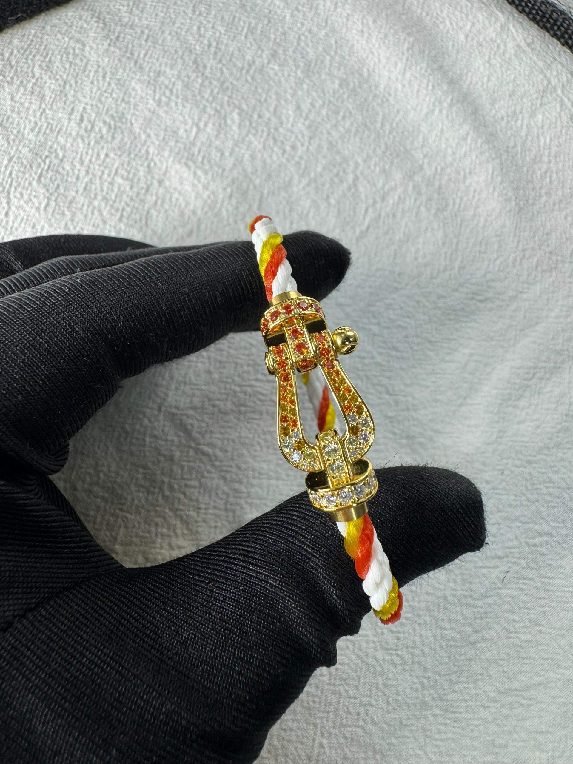 צמיד יוקרתי עם רצועת חבל צבעונית ואבזם בגוון זהב משובץ זירקונים נוצצים
