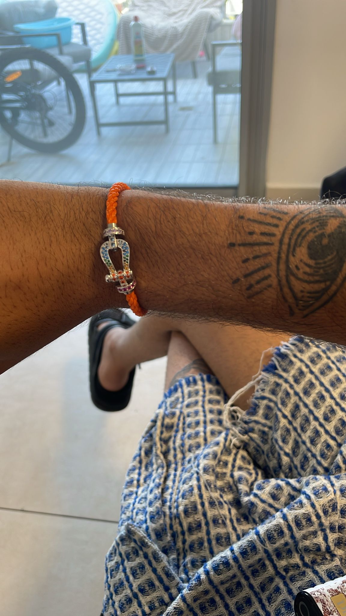 Bracelet luxueux avec des lanières en corde orange et une boucle en argent parsemée de zircons colorés
