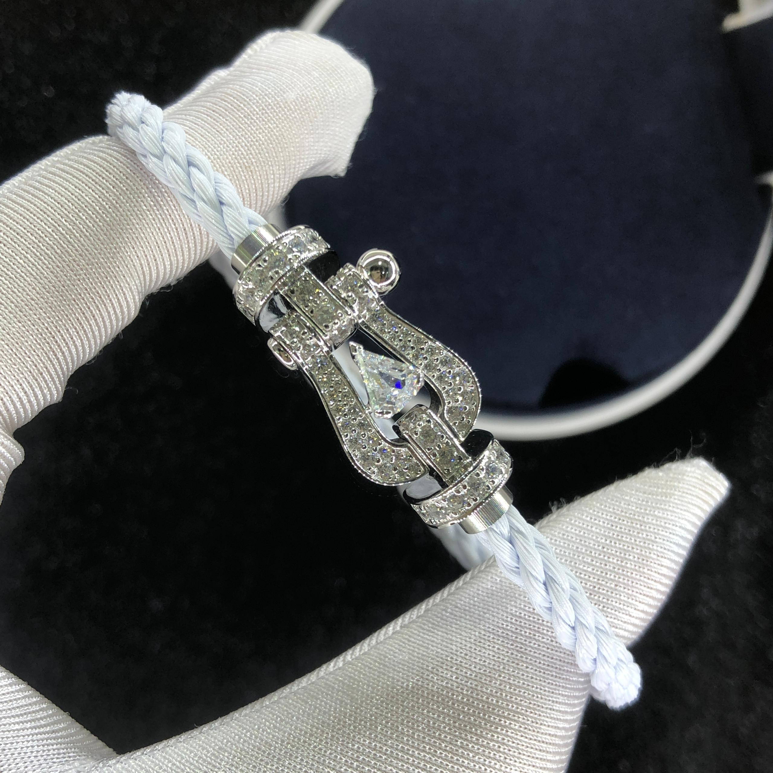 Bracelet luxueux avec une sangle en corde blanche et une boucle argentée parsemée de zircons, avec une pierre centrale de 0,5 carat