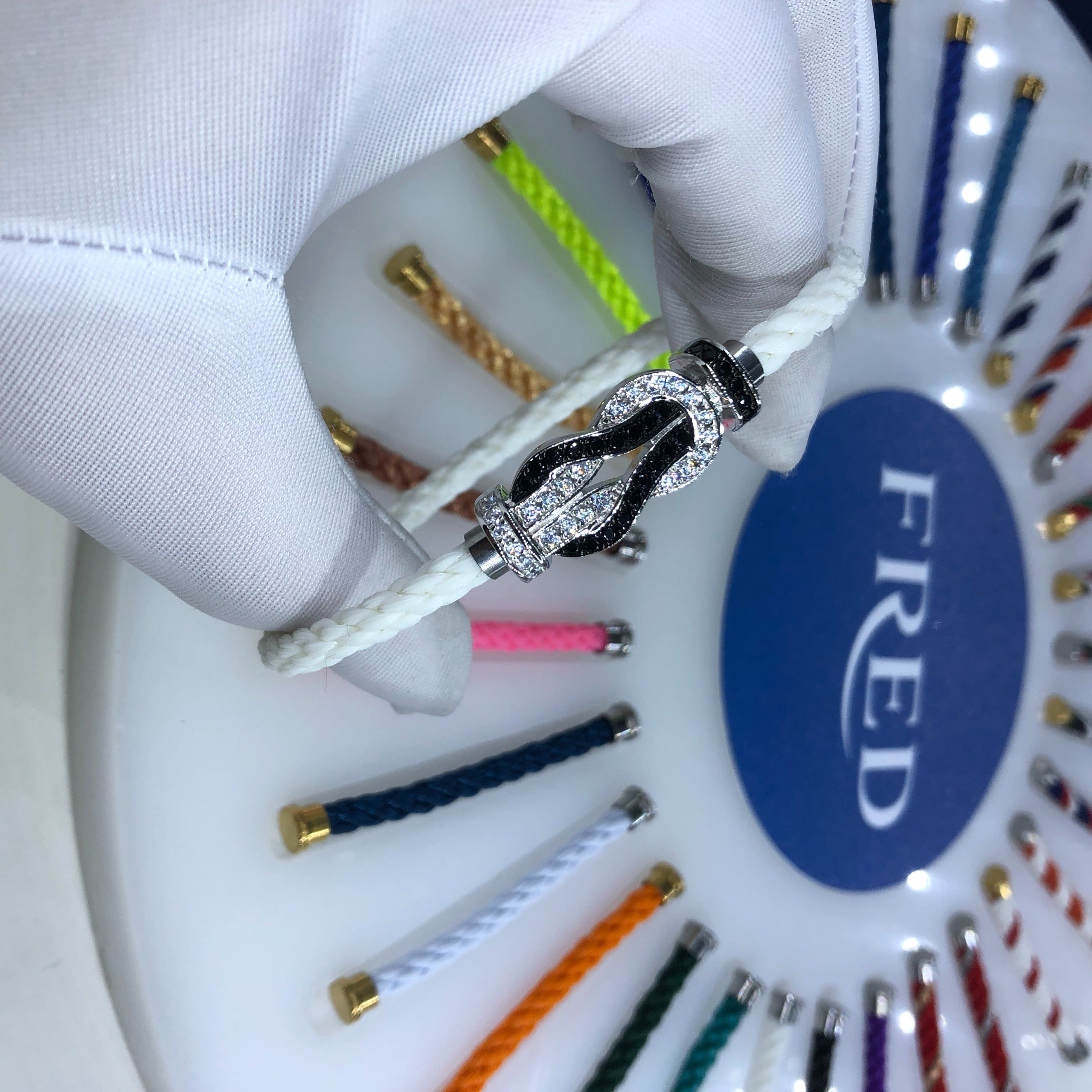 צמיד יוקרתי עם רצועת חבל לבנה ואבזם אינסוף בגוון כסף משובץ זירקונים נוצצים