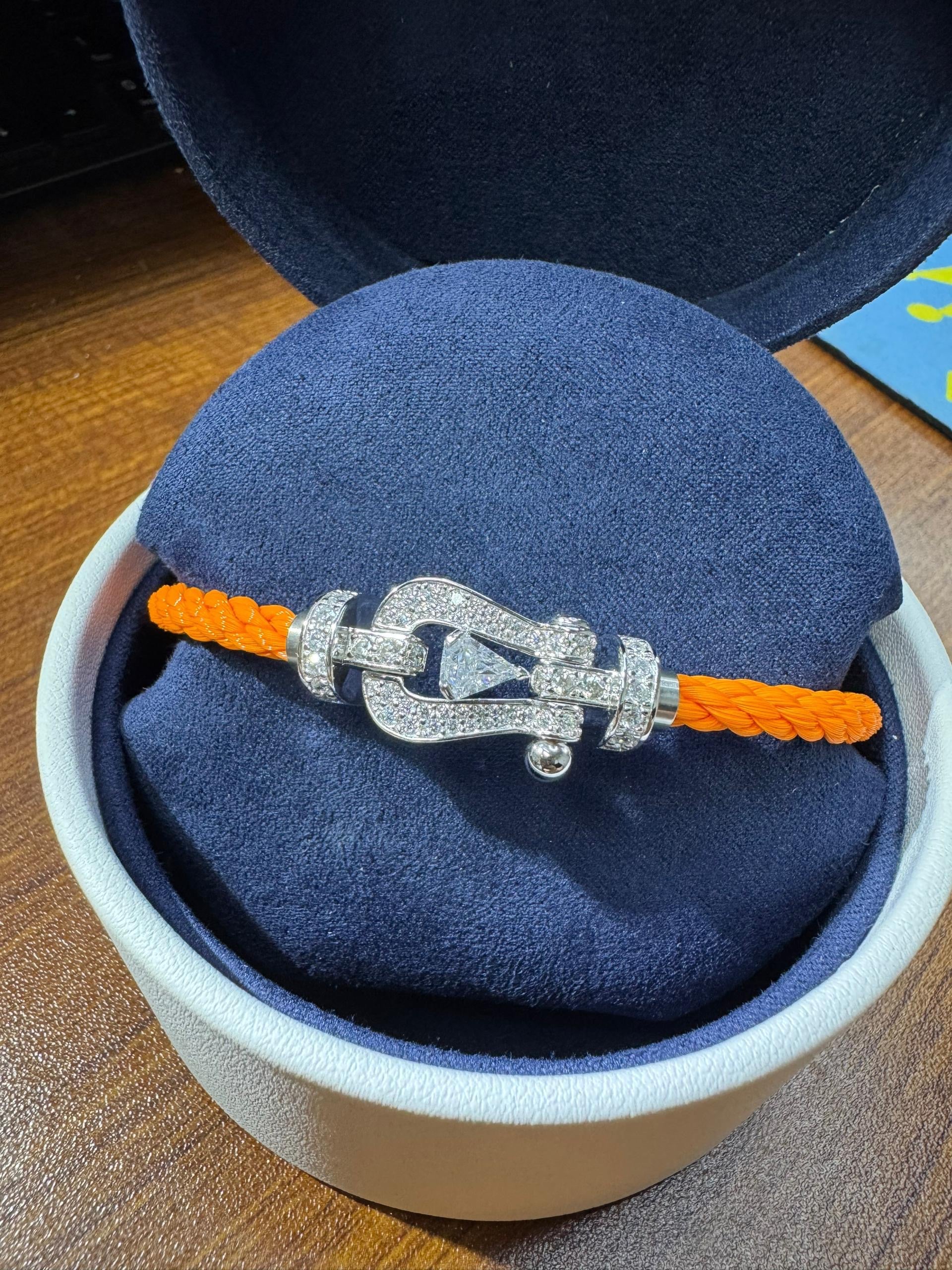 Bracelet luxueux avec une sangle en corde noire et une boucle couleur or rose sertie de zircons, avec une pierre centrale de 0,5 carat