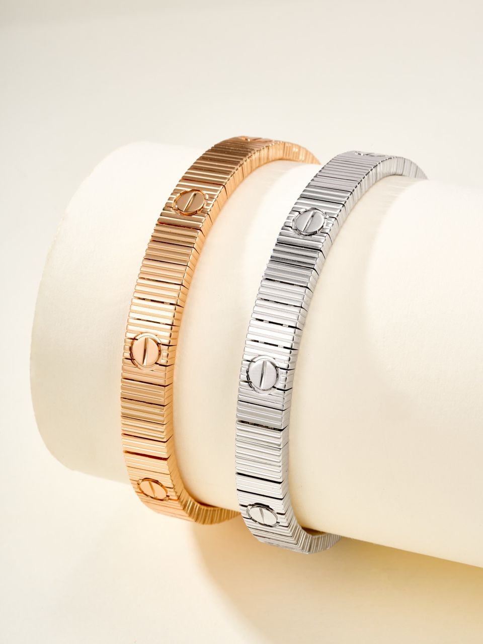 צמיד אלגנטי בגוון זהב ורוד מבריק עם פסים בעיצוב מודרני ונקי