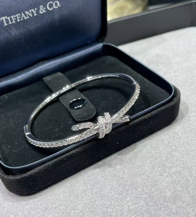 צמיד קשר עדין בגוון כסף משובץ זירקונים נוצצים למראה יוקרתי