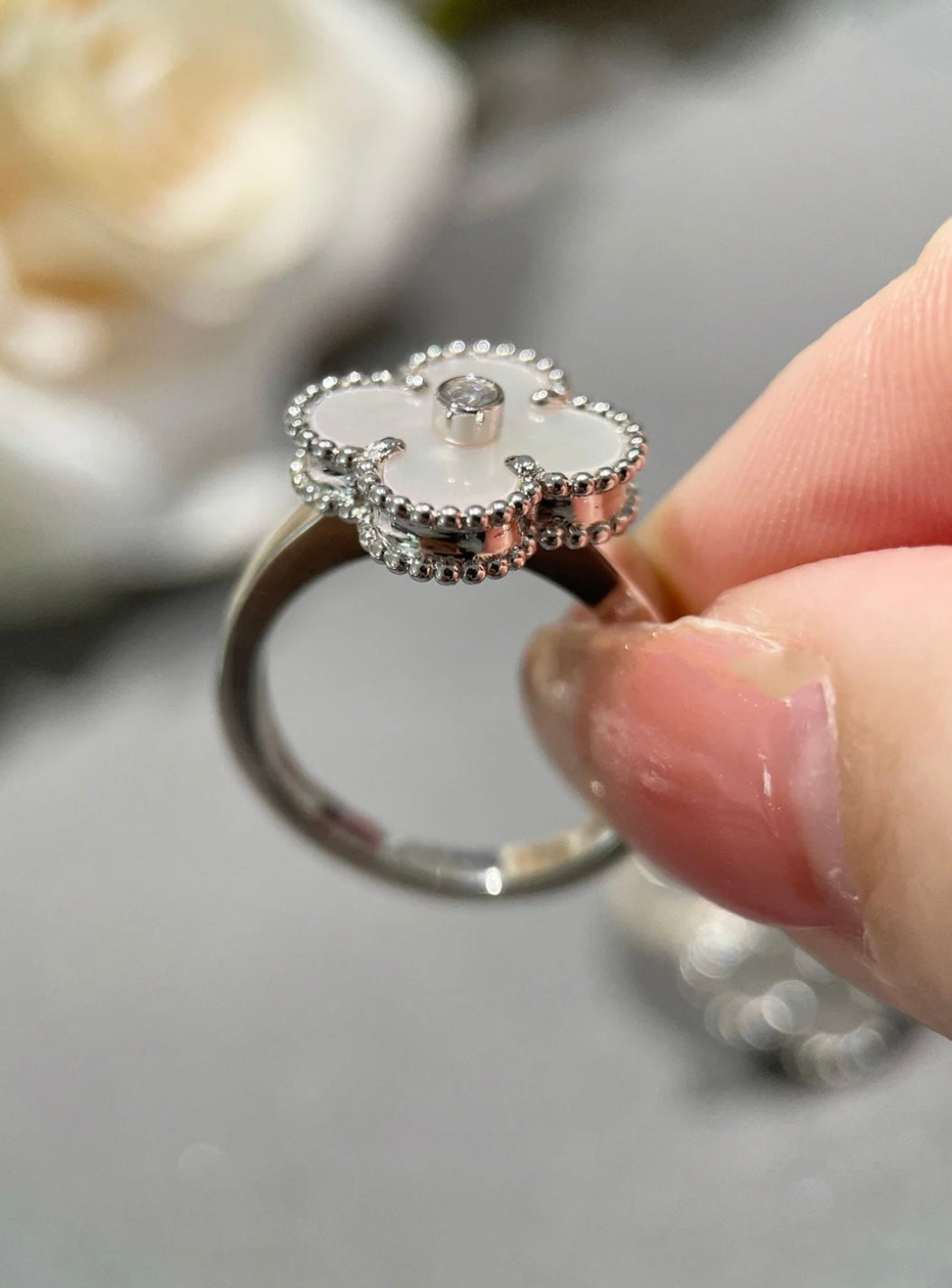 Weißer Kleeblatt-Ring, in der Mitte mit einem funkelnden Zirkon besetzt