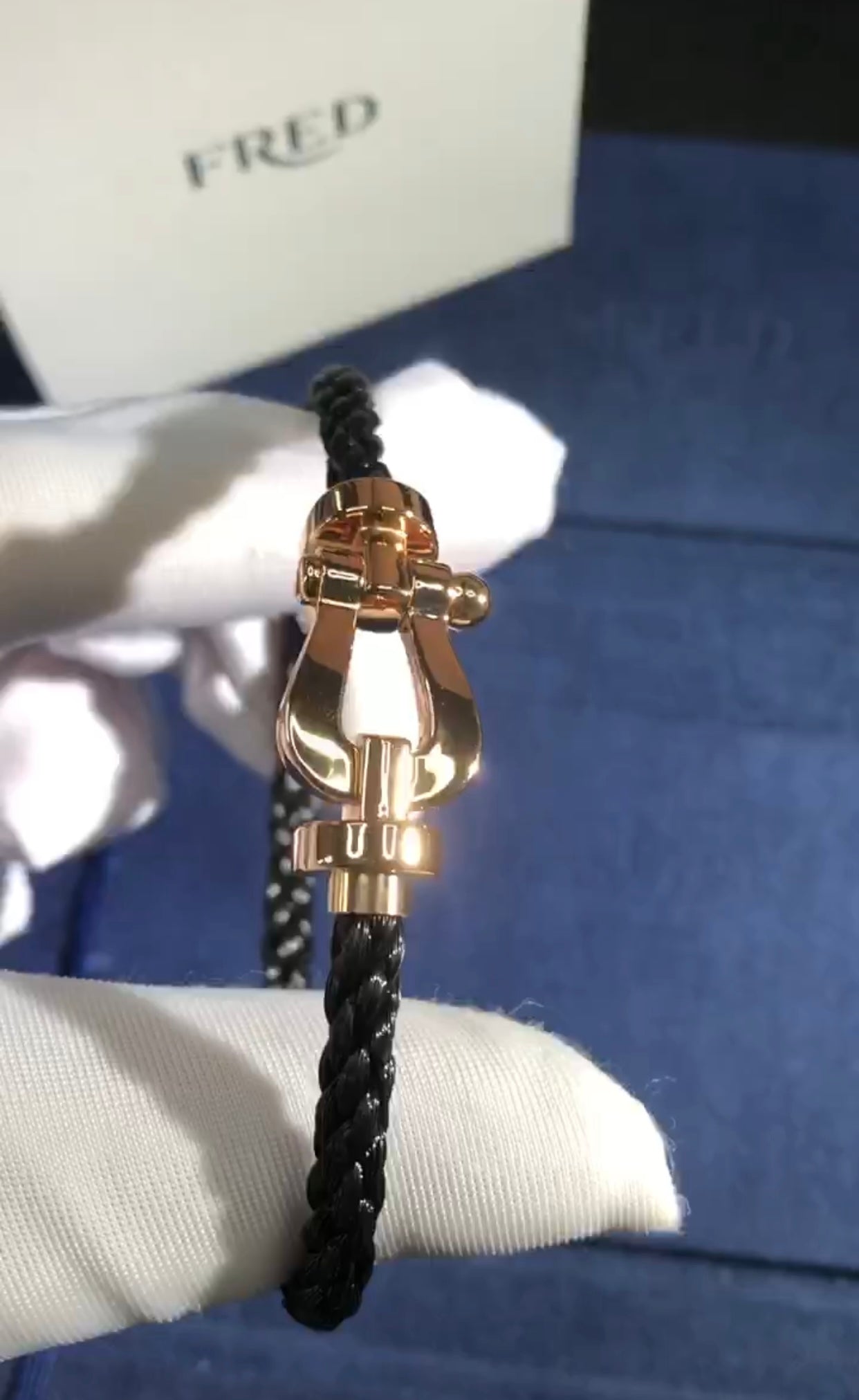 צמיד יוקרתי עם רצועת חבל שחורה ואבזם בגוון רוז־גולד מבריק