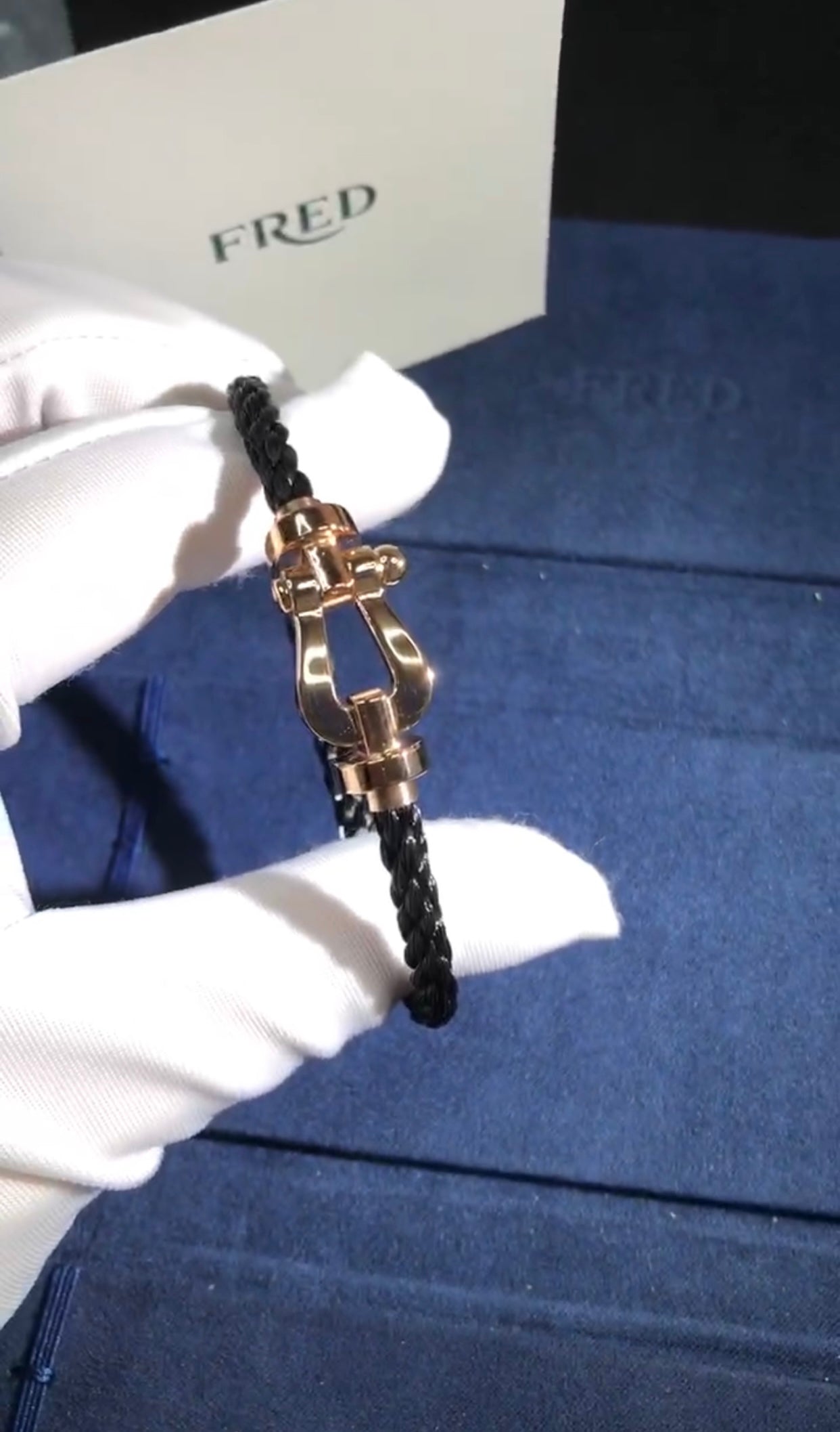 צמיד יוקרתי עם רצועת חבל שחורה ואבזם בגוון רוז־גולד מבריק