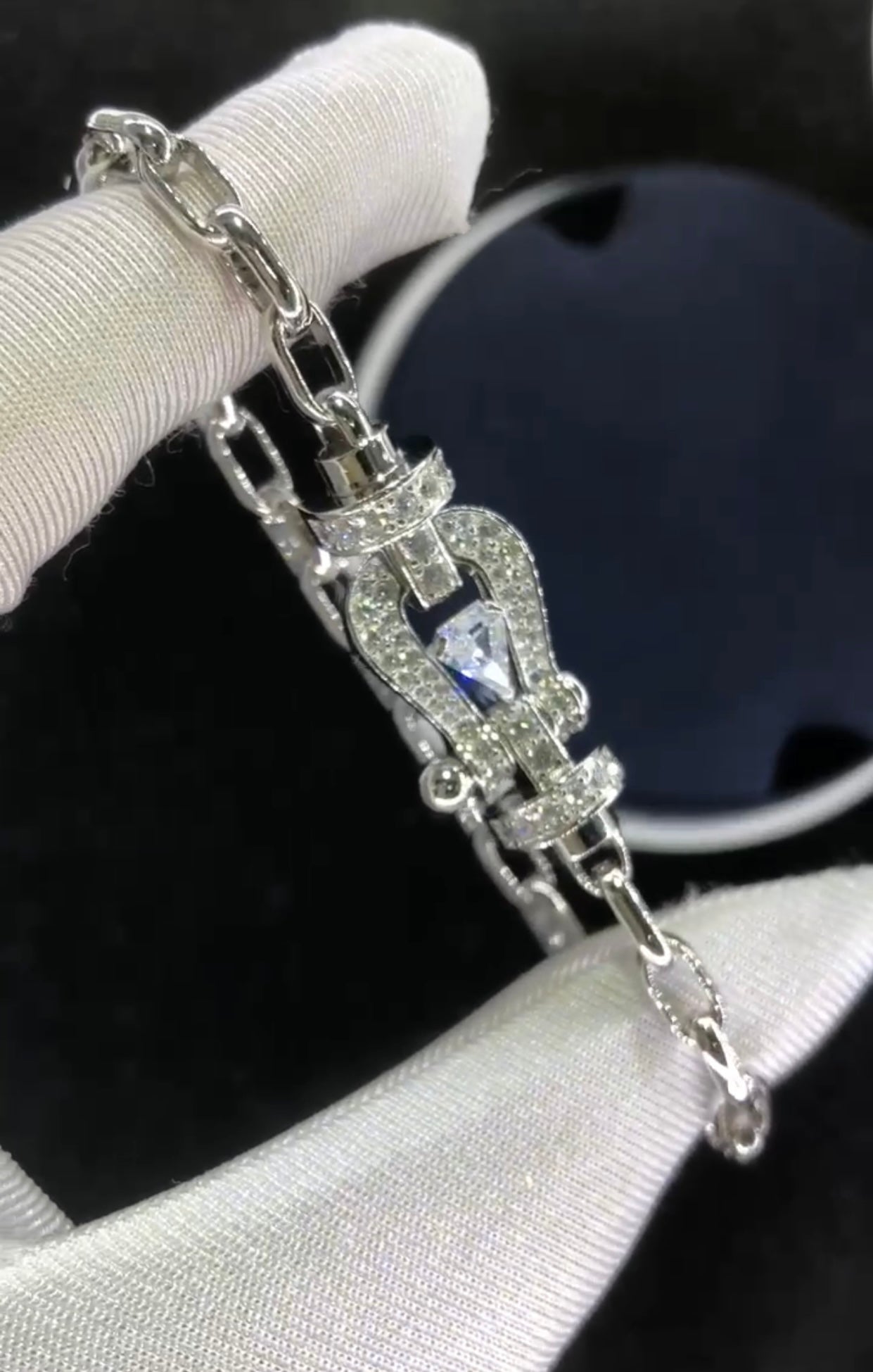 Bracelet luxueux avec une chaîne en argent et une boucle argentée parsemée de zircons, avec une pierre centrale de 0,5 carat