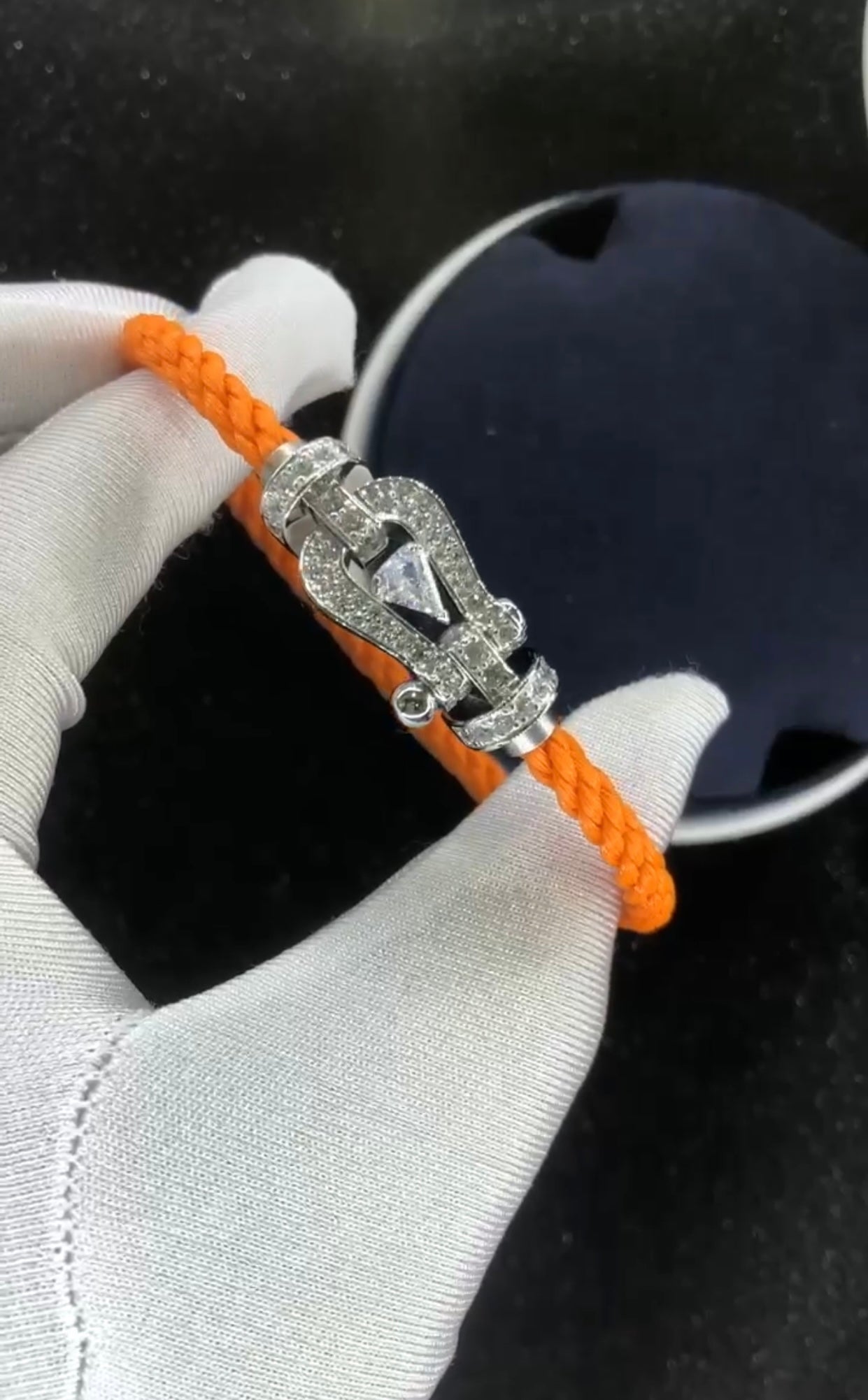Bracelet luxueux avec une sangle en corde noire et une boucle couleur or rose sertie de zircons, avec une pierre centrale de 0,5 carat