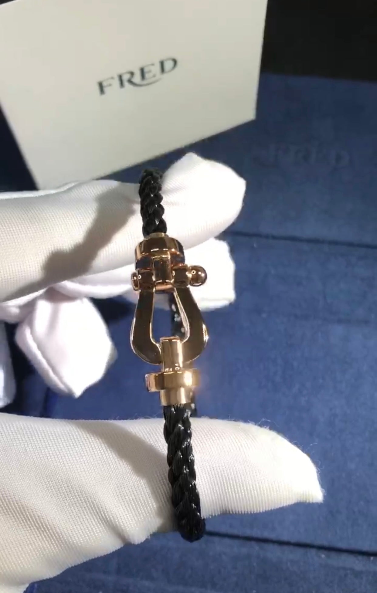 צמיד יוקרתי עם רצועת חבל שחורה ואבזם בגוון רוז־גולד מבריק