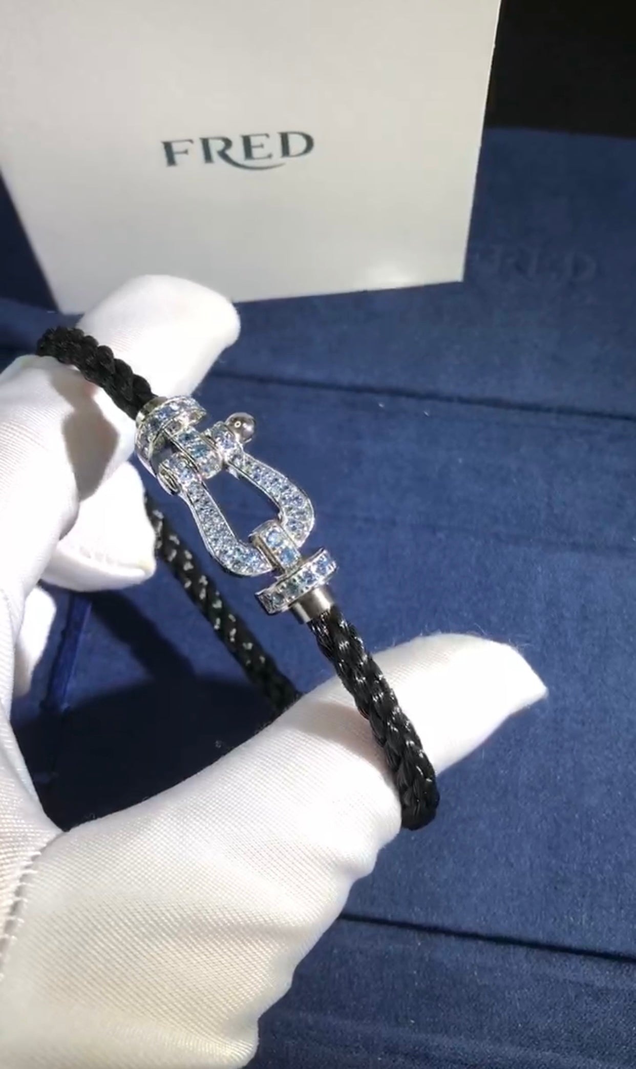 צמיד יוקרתי עם רצועת חבל שחורה ואבזם בגוון כסף משובץ זירקונים בגוון תכלת