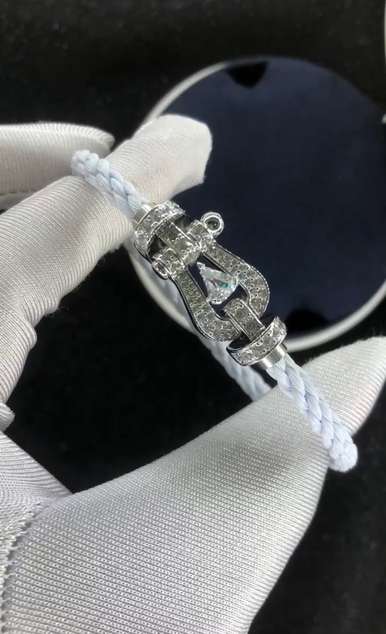 Bracelet luxueux avec une sangle en corde blanche et une boucle argentée parsemée de zircons, avec une pierre centrale de 0,5 carat